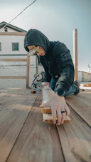 A person wearing safety glasses cuts wood with a saw.