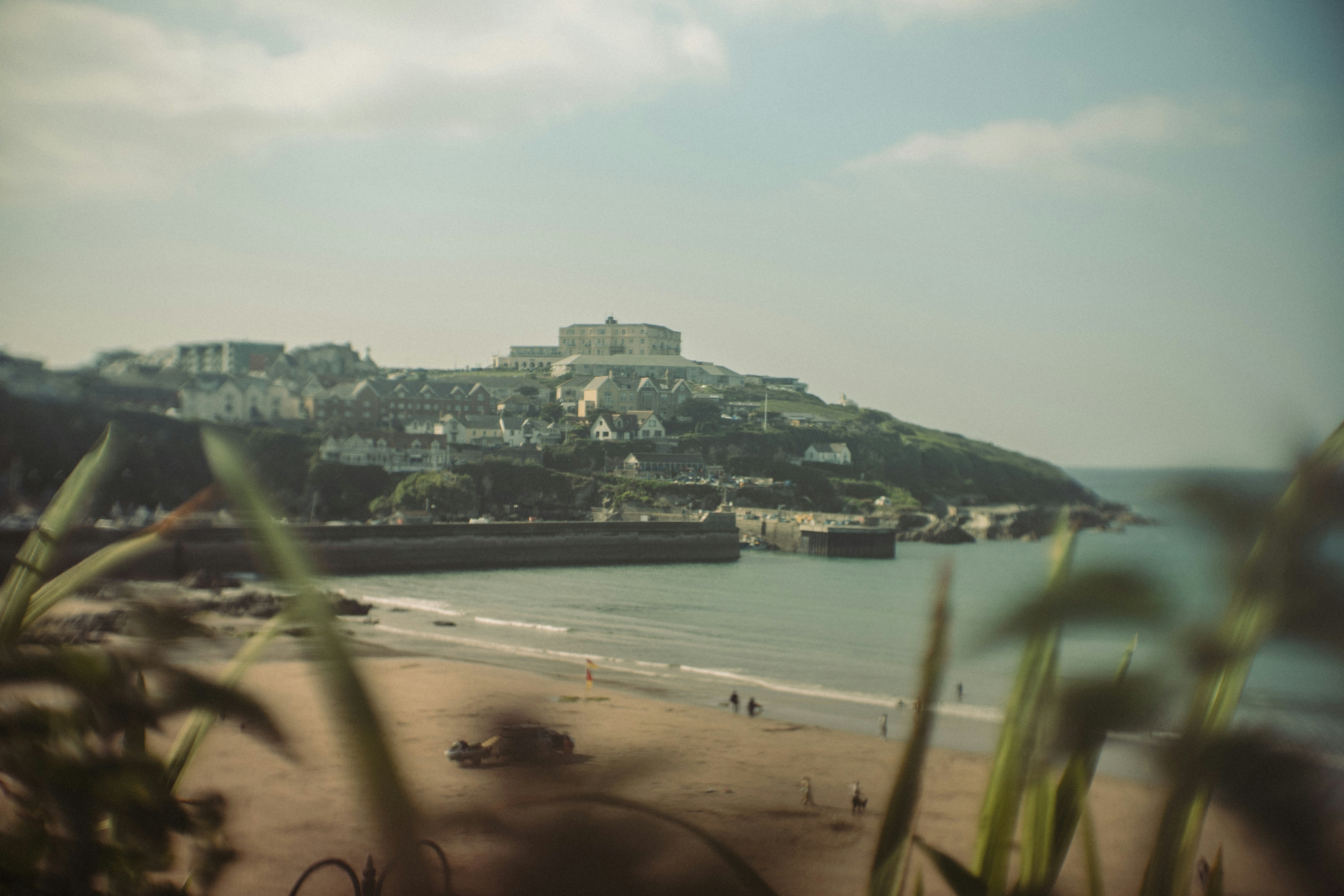 Coastal town with buildings on a hill overlooking the sea.