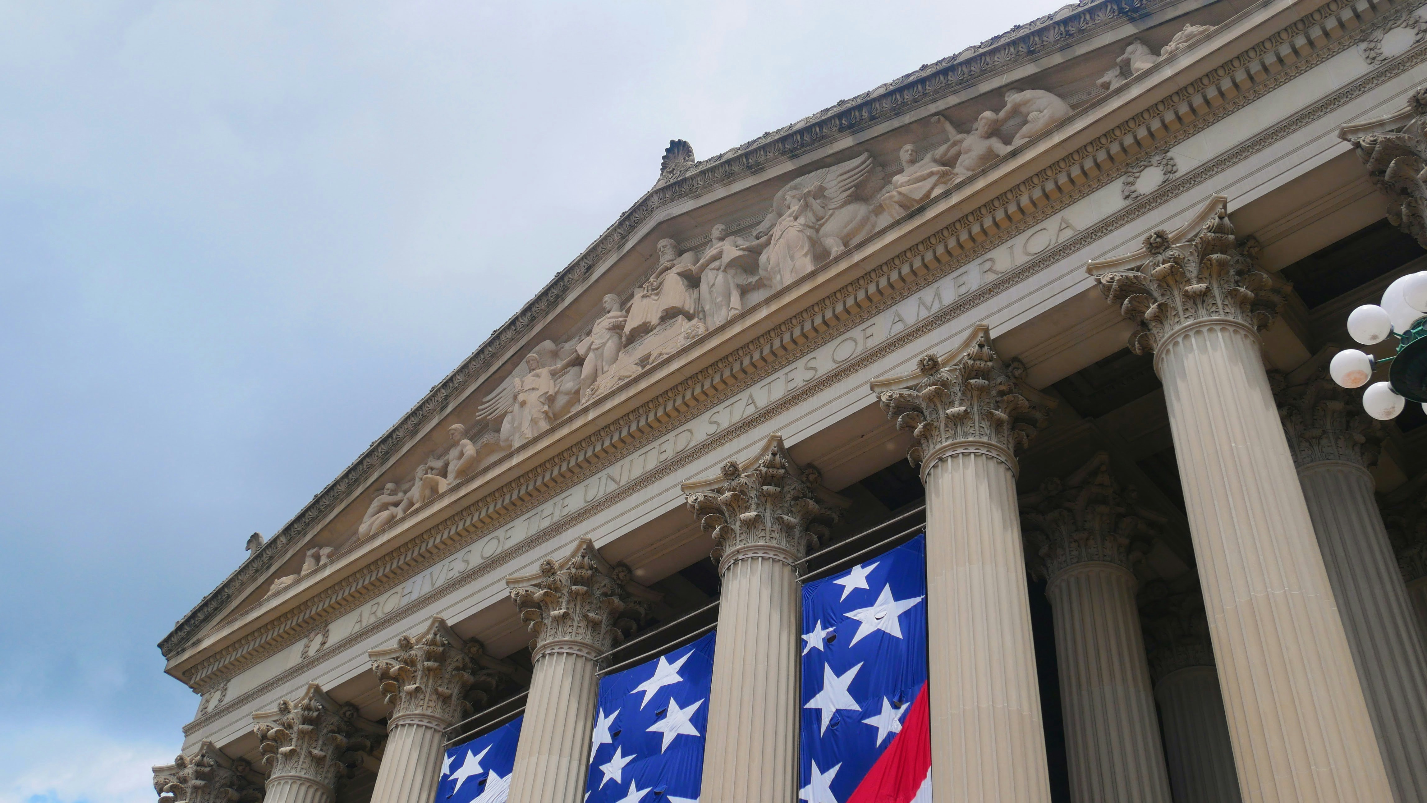 Grand building with columns and american flag banner.