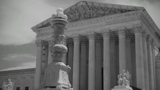 The supreme court building with a statue in the foreground