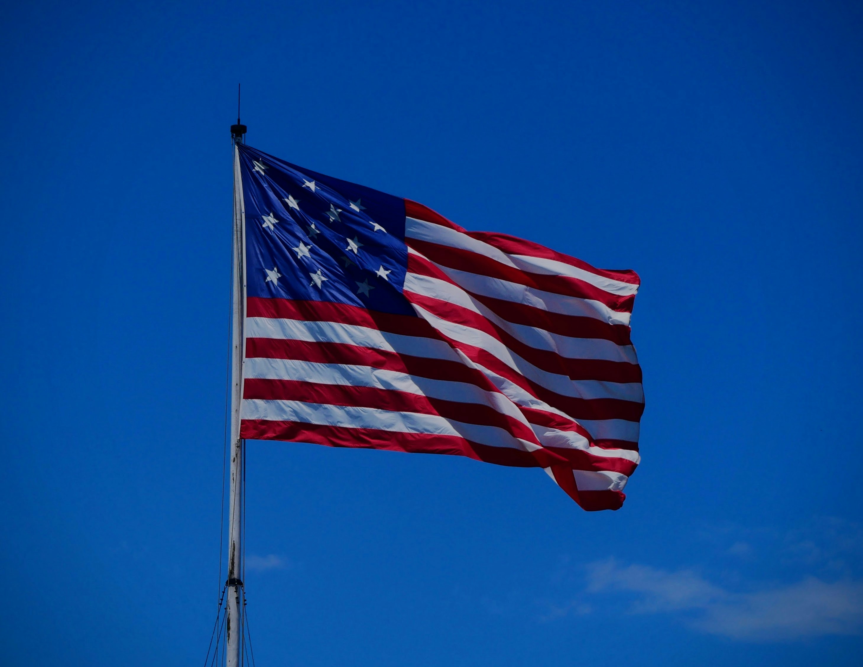 American flag waving against a clear blue sky