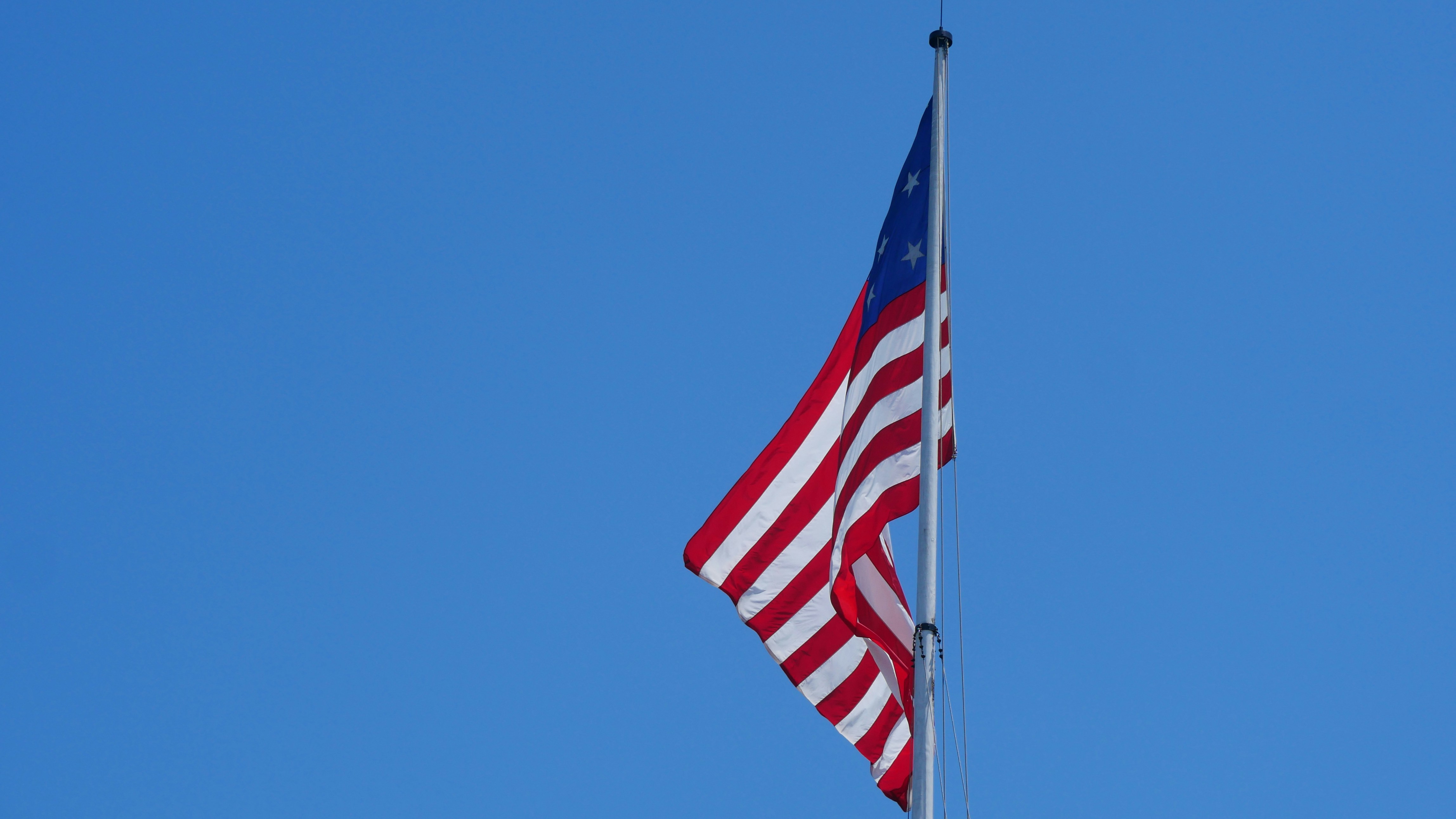 American flag waving against a clear blue sky