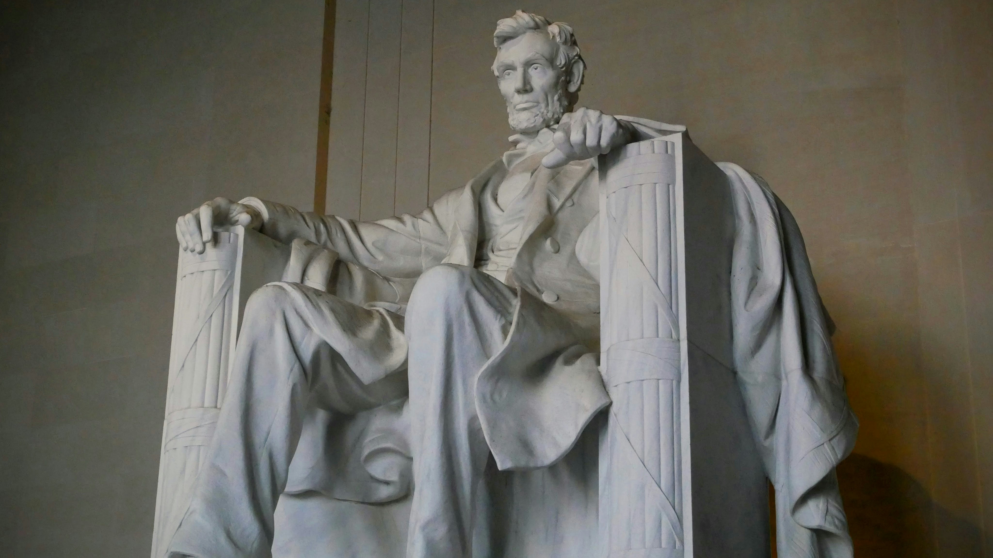 The lincoln memorial statue sits solemnly indoors.