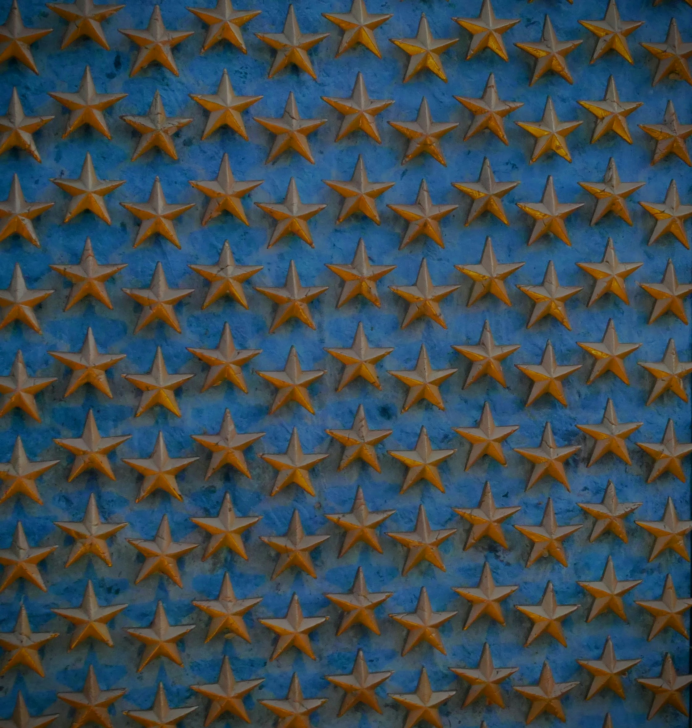 Um padrão de estrelas douradas sobre fundo azul.