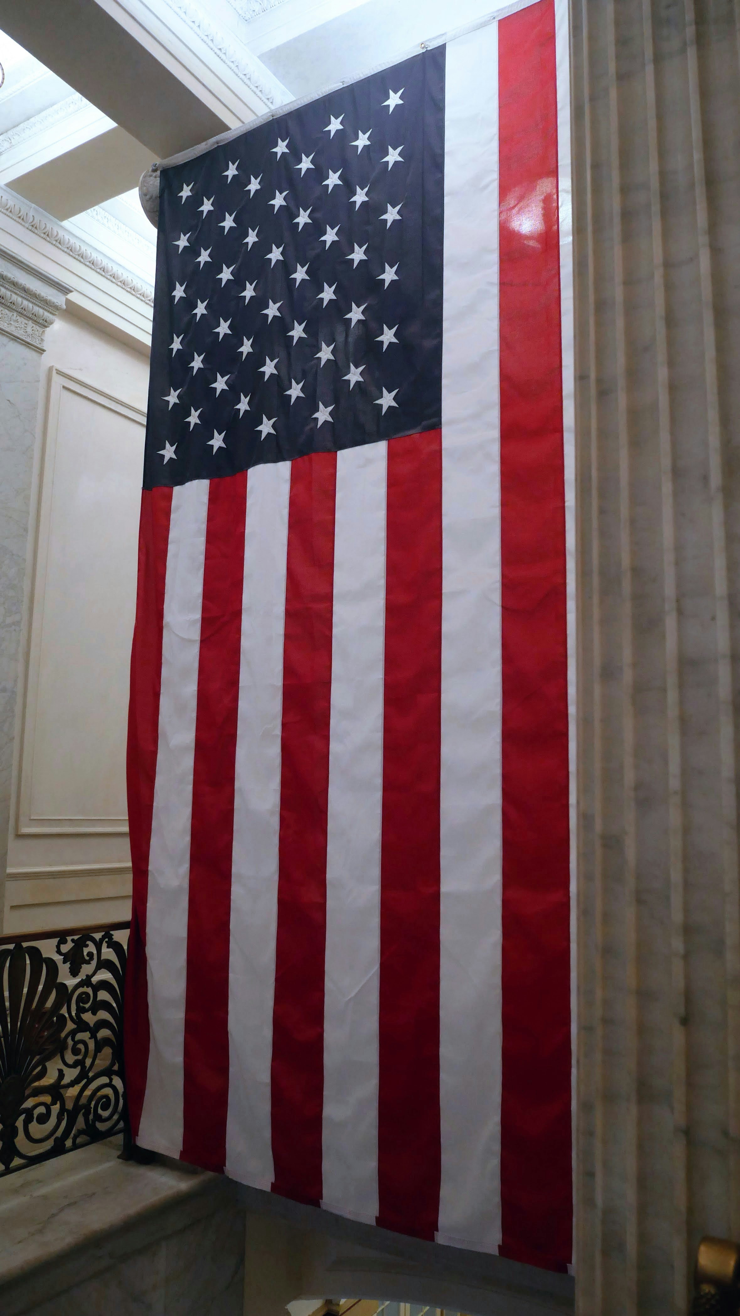 American flag hanging indoors with columns.