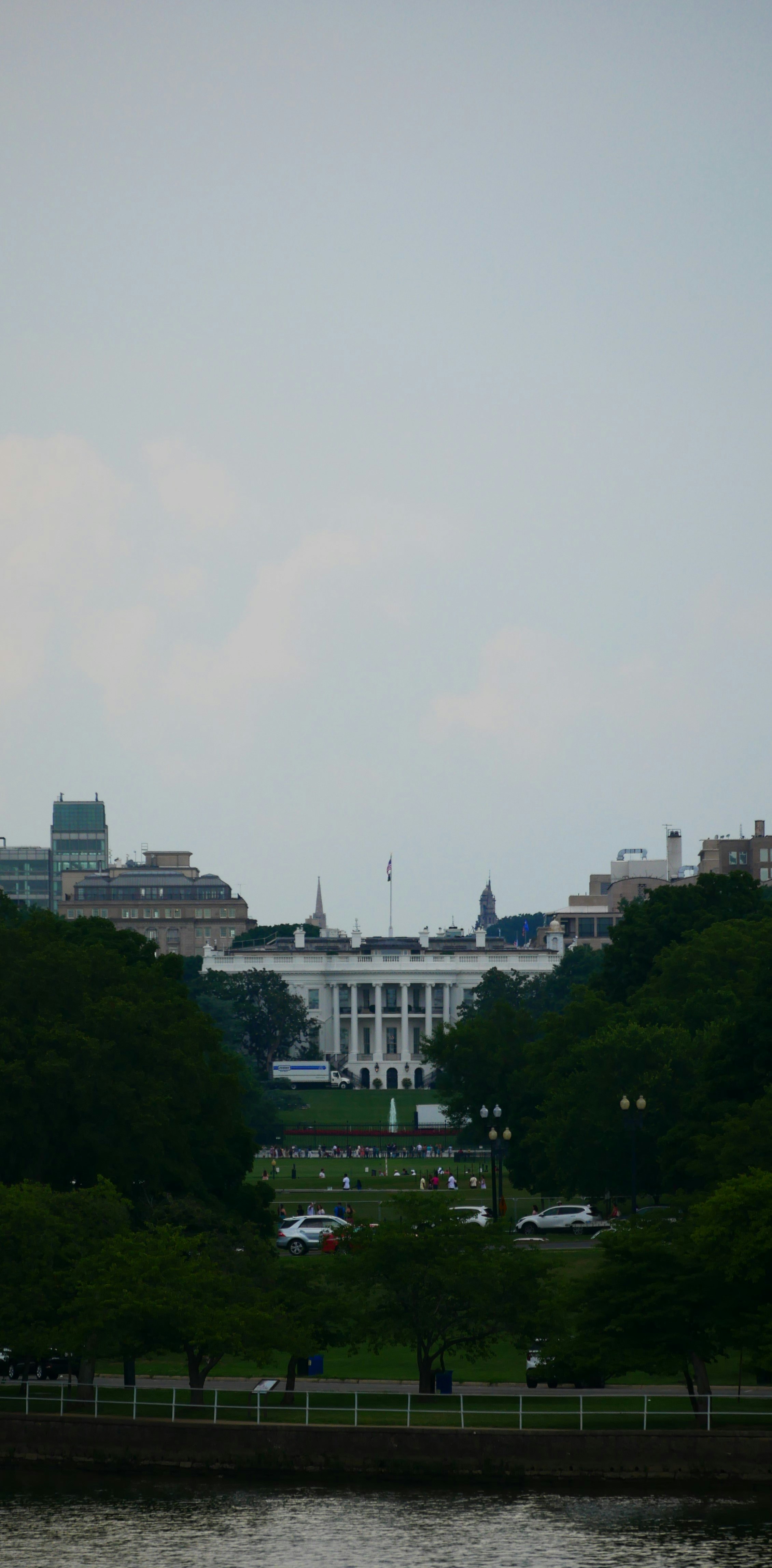 The white house with trees and a river in foreground.