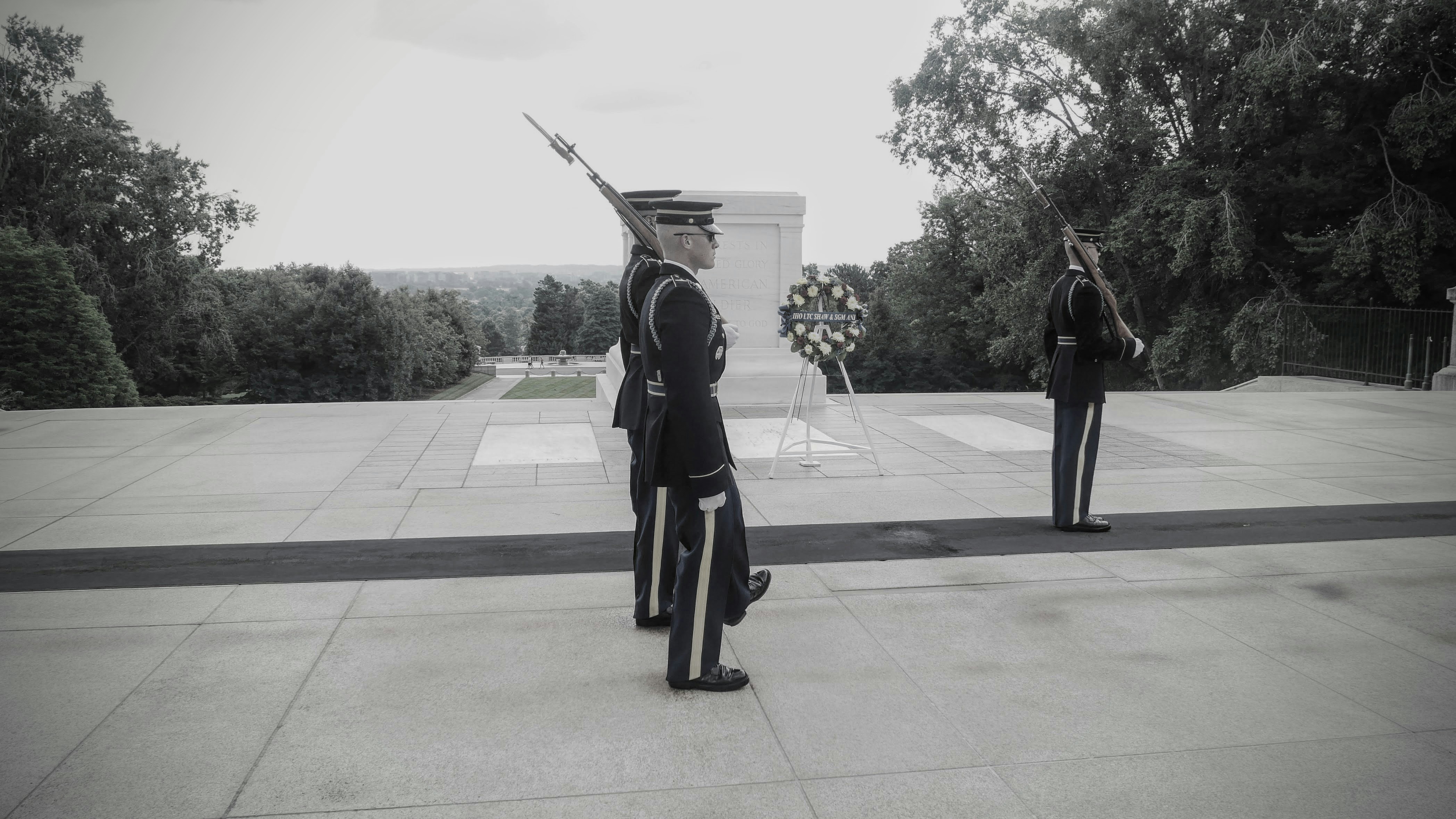 Guards stand at attention near a monument.