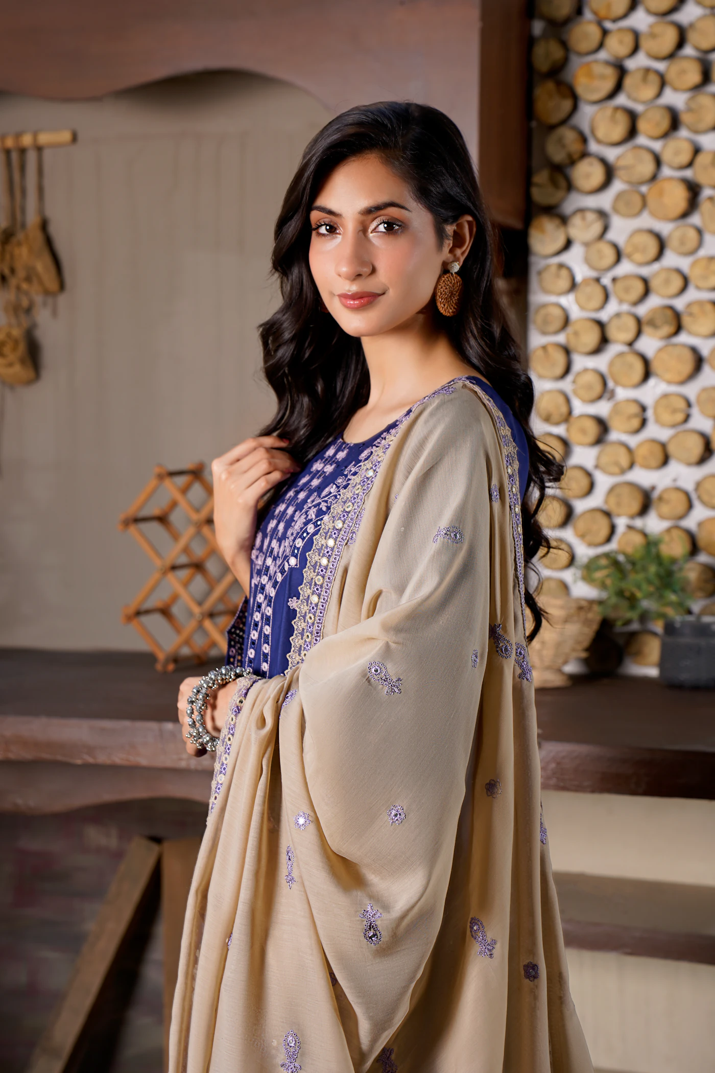 Model wearing a blue embroidered Pakistani suit with a shawl