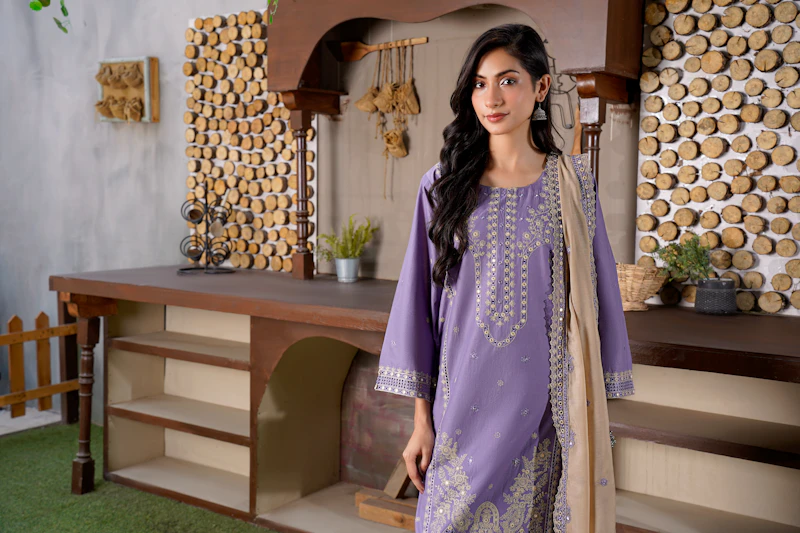 Woman in a purple embroidered outfit indoors