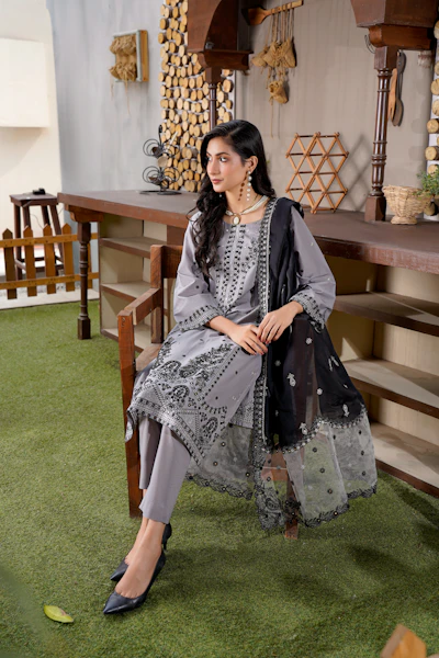A woman in a grey traditional outfit with black scarf.