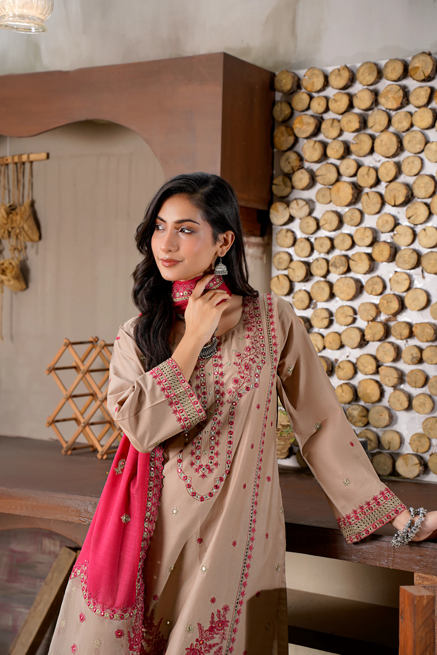 Model wearing a taupe embroidered suit with a pink dupatta