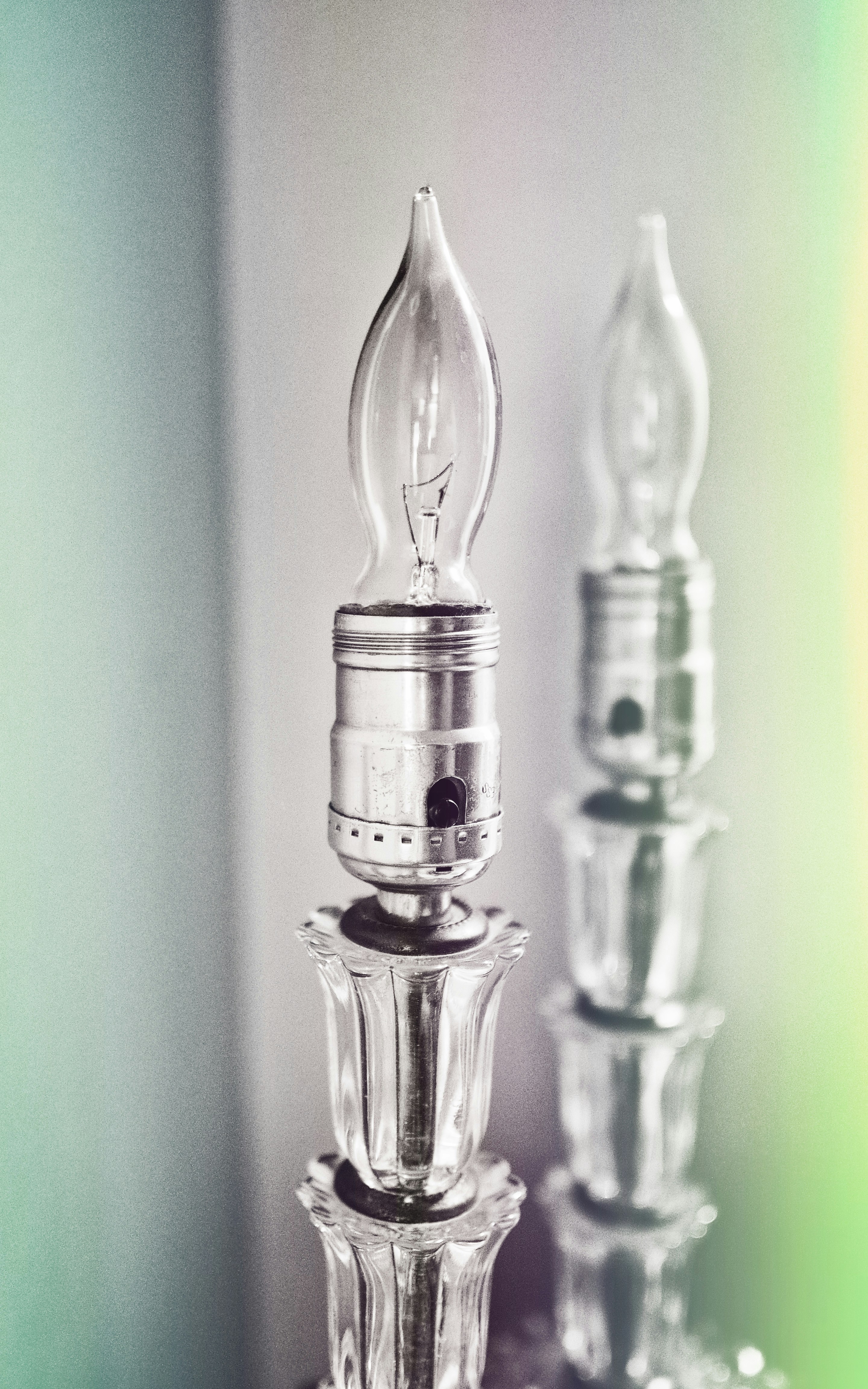 Due lampadine trasparenti a forma di fiamma su basi di cristallo