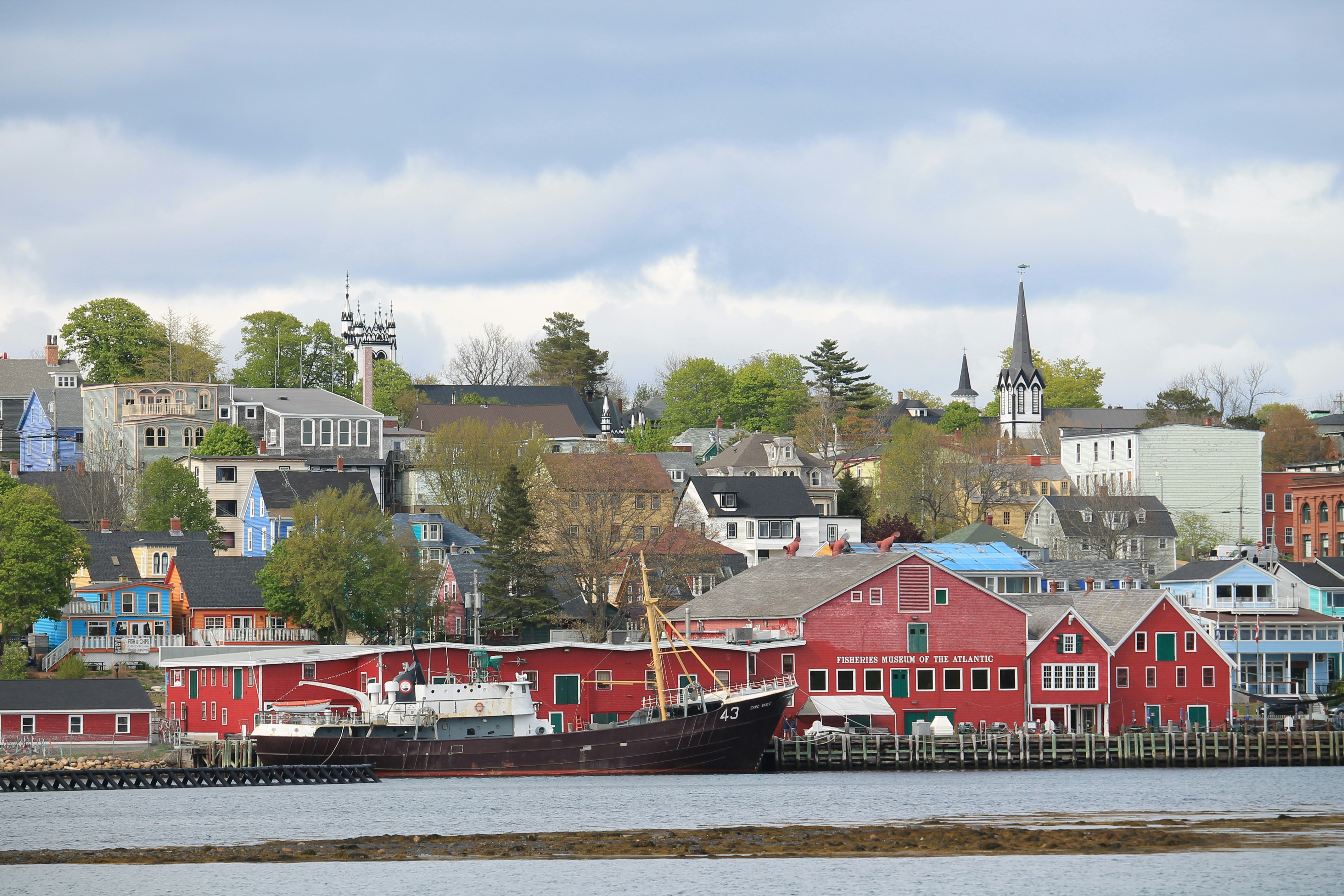 Coastal town with red buildings and a ship.