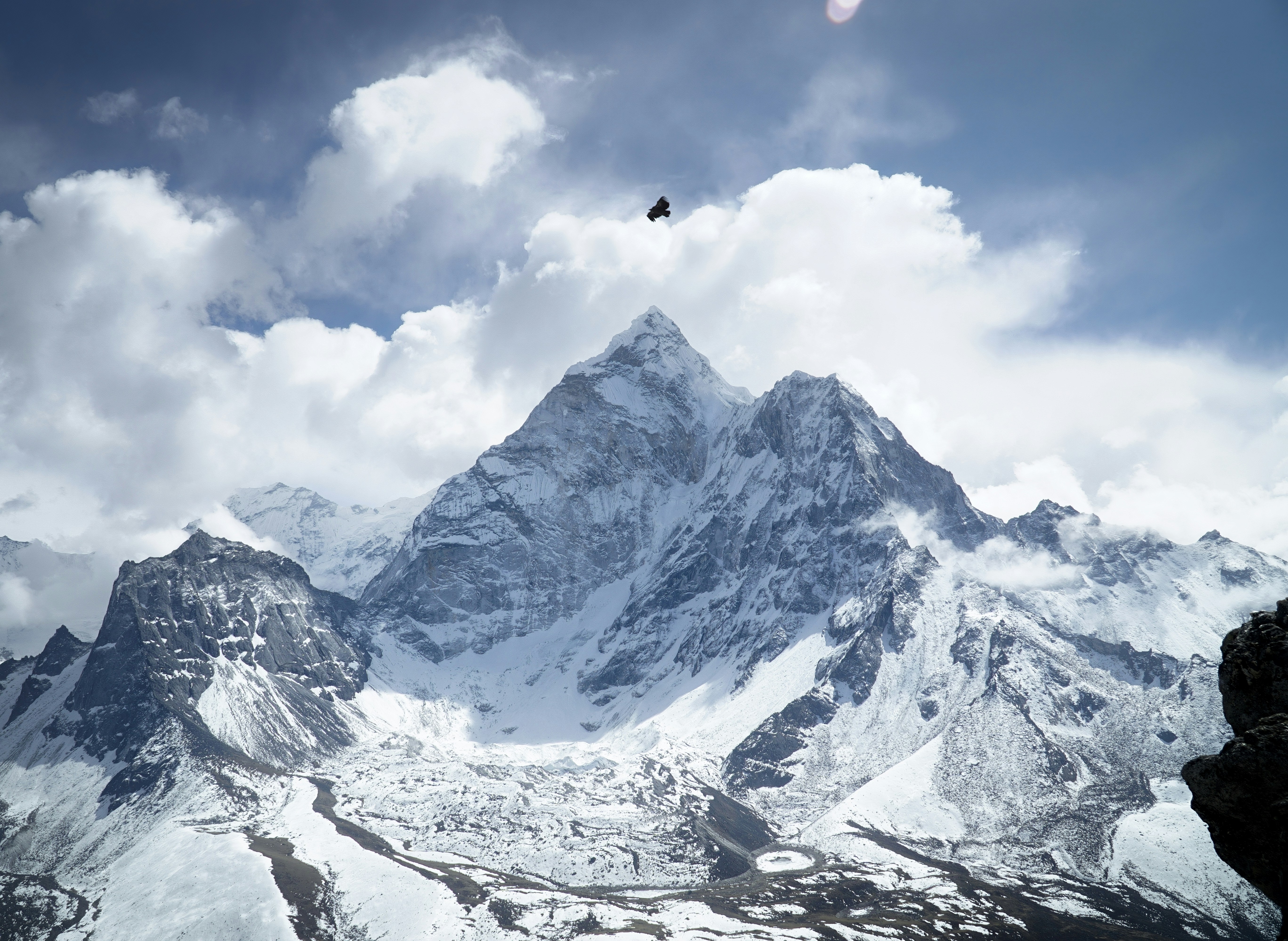 A majestic snow-capped mountain peak under a cloudy sky