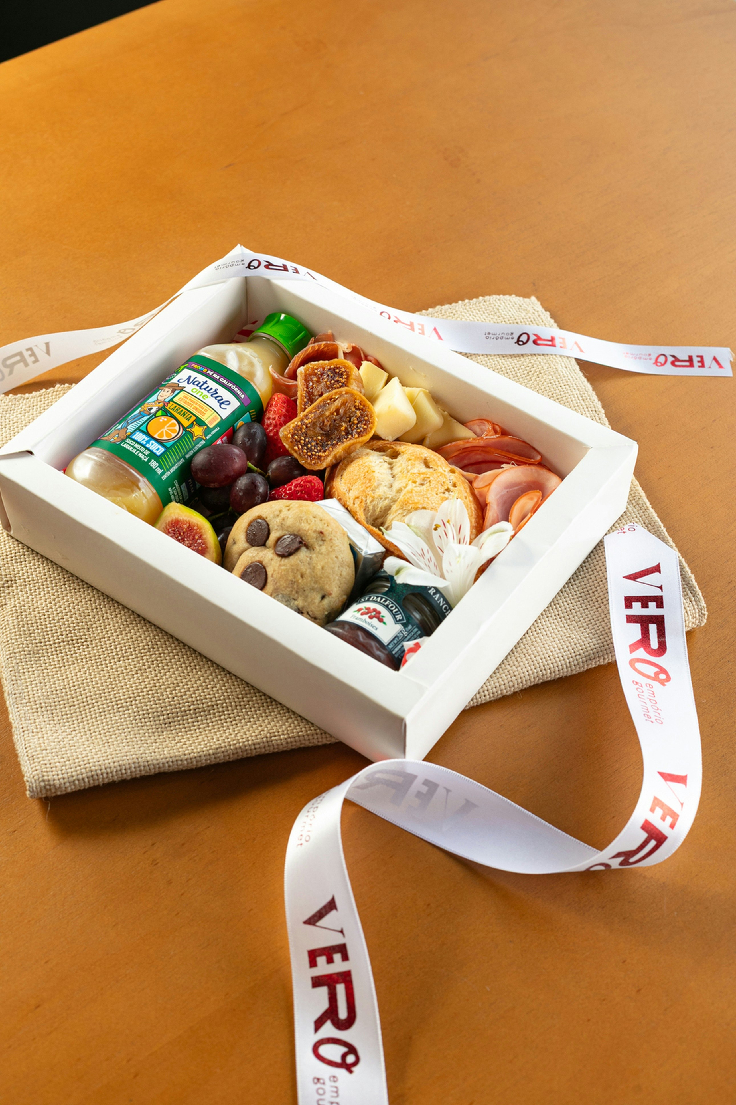 Gourmet food gift box with fruits, cookies, and cheese.
