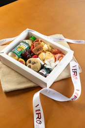 Gourmet food gift box with fruits, cookies, and cheese.