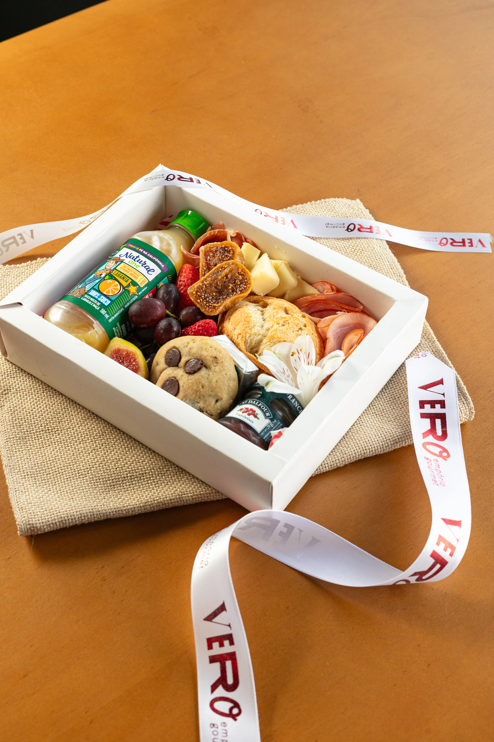 Gourmet food gift box with fruits, cookies, and cheese.