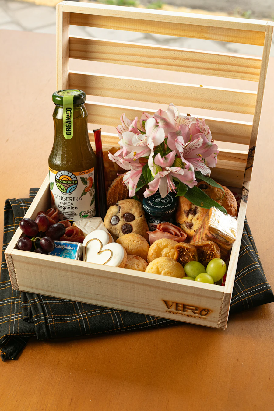 Wooden crate hamper filled with food, flowers and a drink