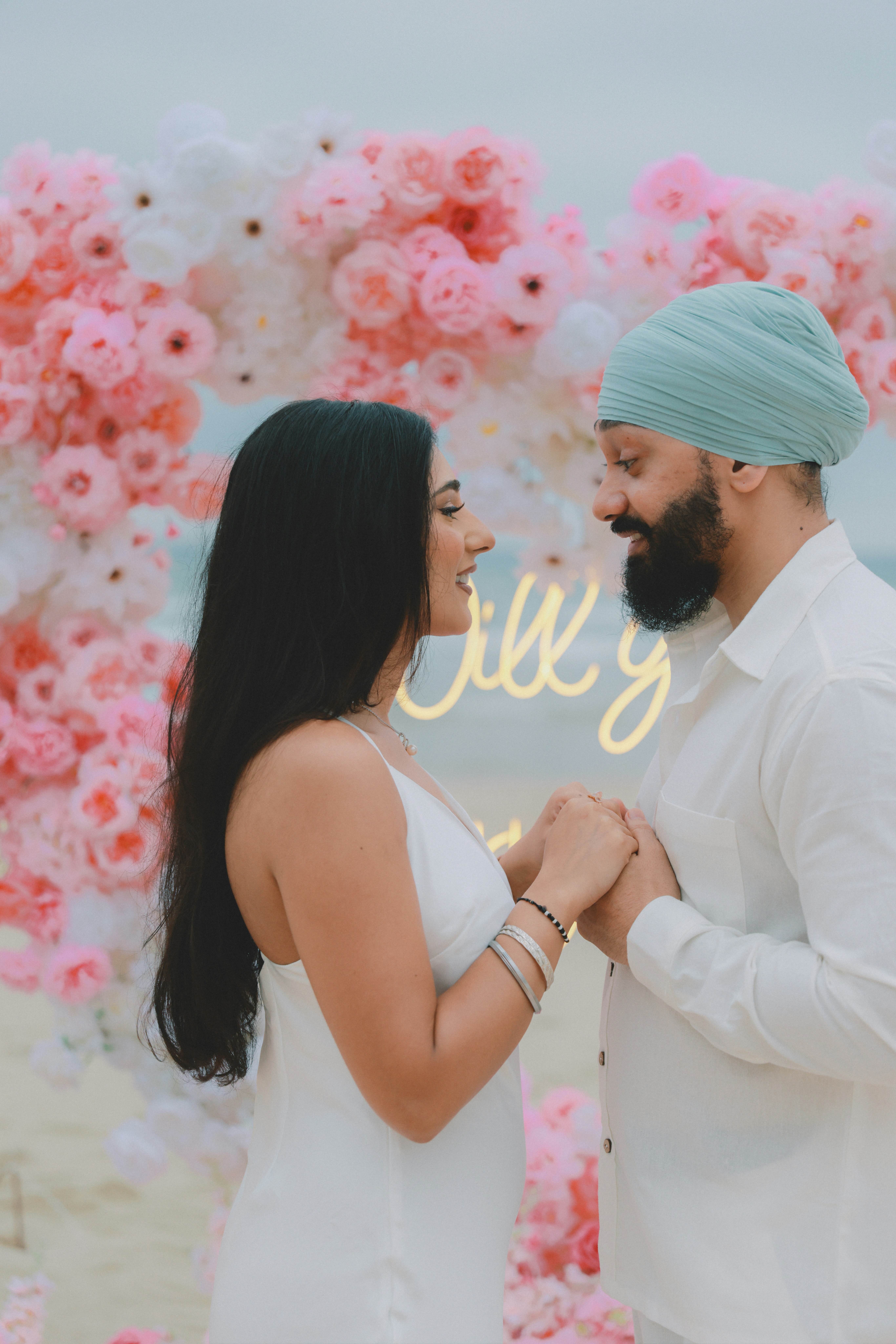 Couple se tenant la main devant l’arc floral