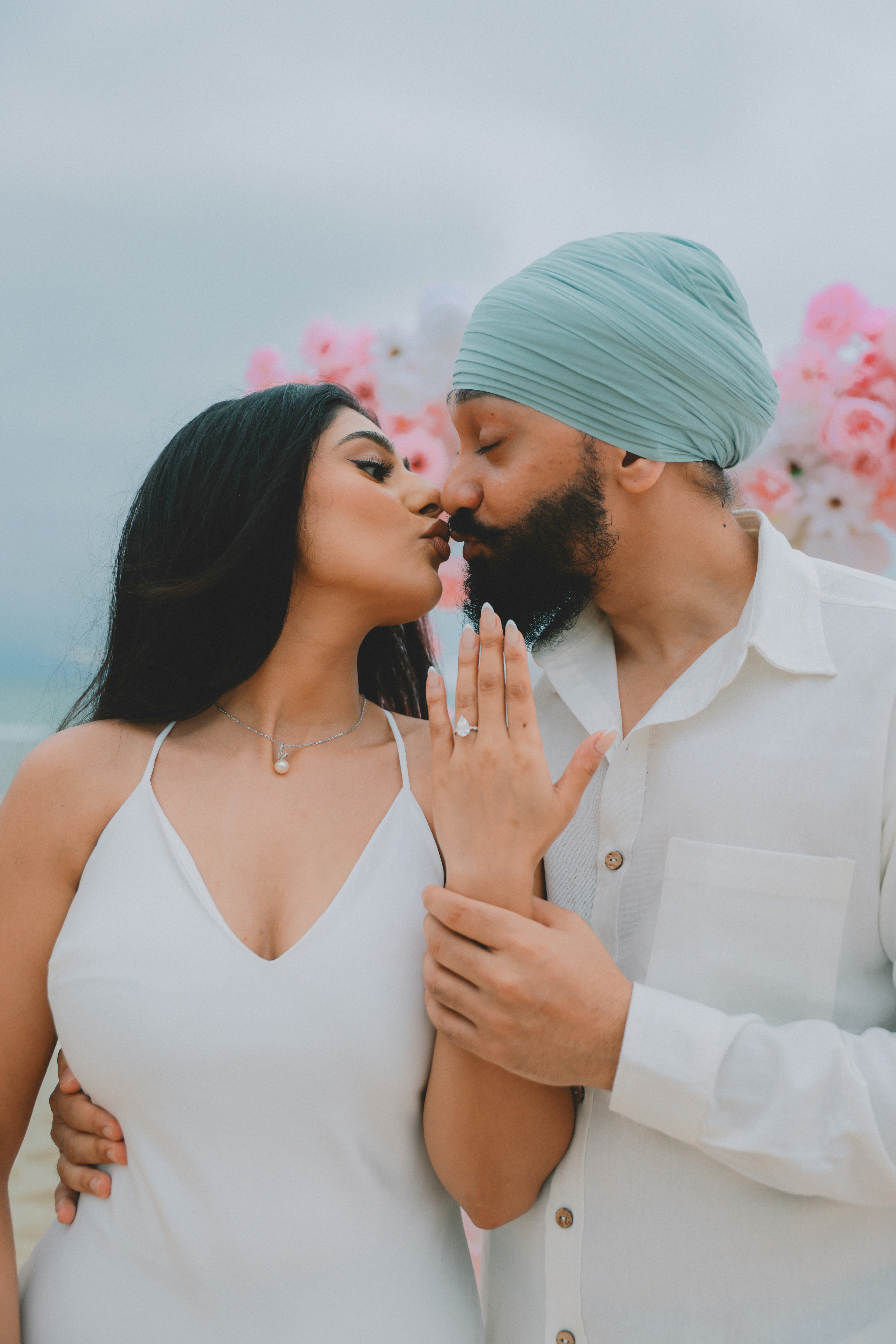 Couple s’embrassant avec une bague de fiançailles visible
