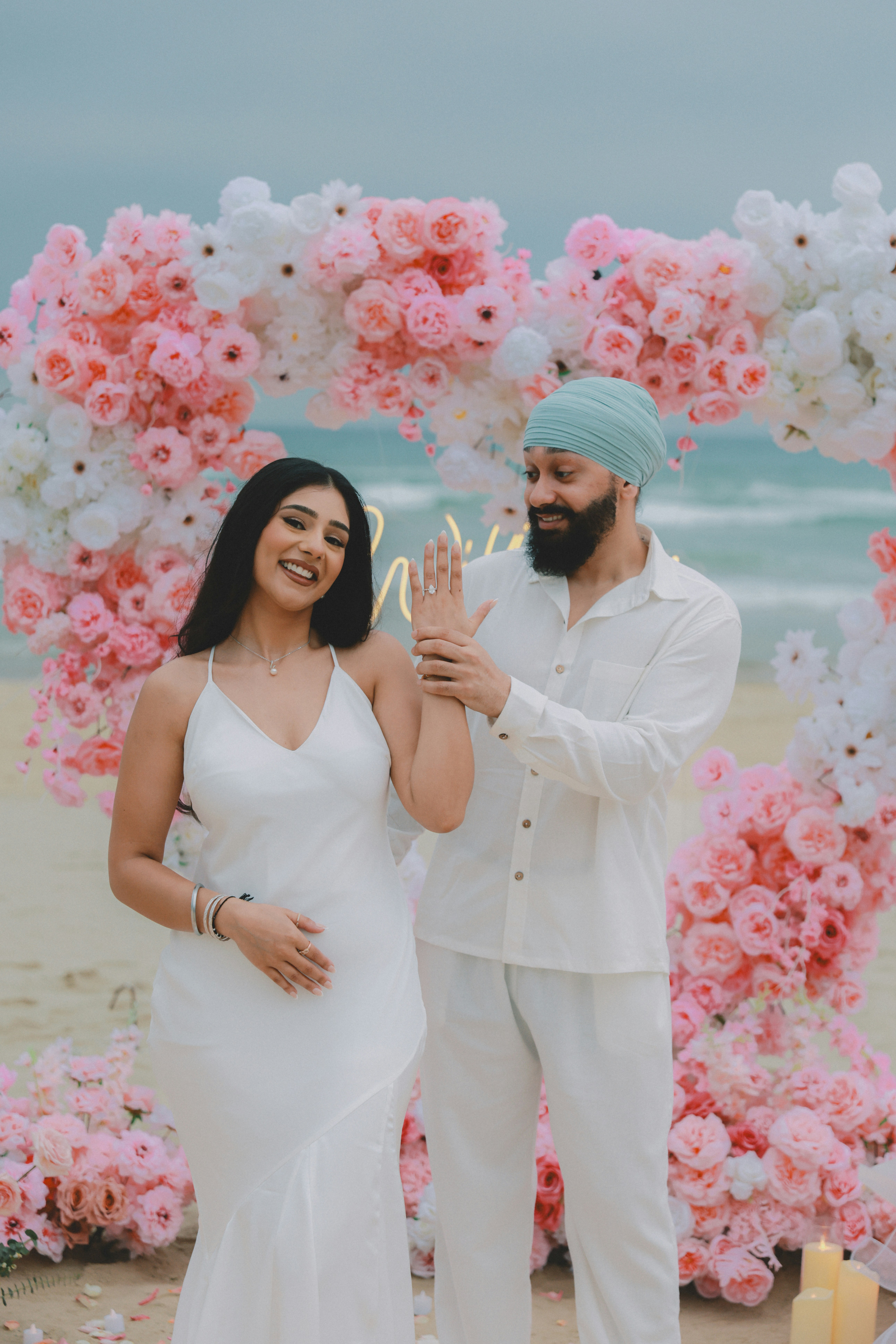 Couple posant pour des photos de fiançailles sur une plage