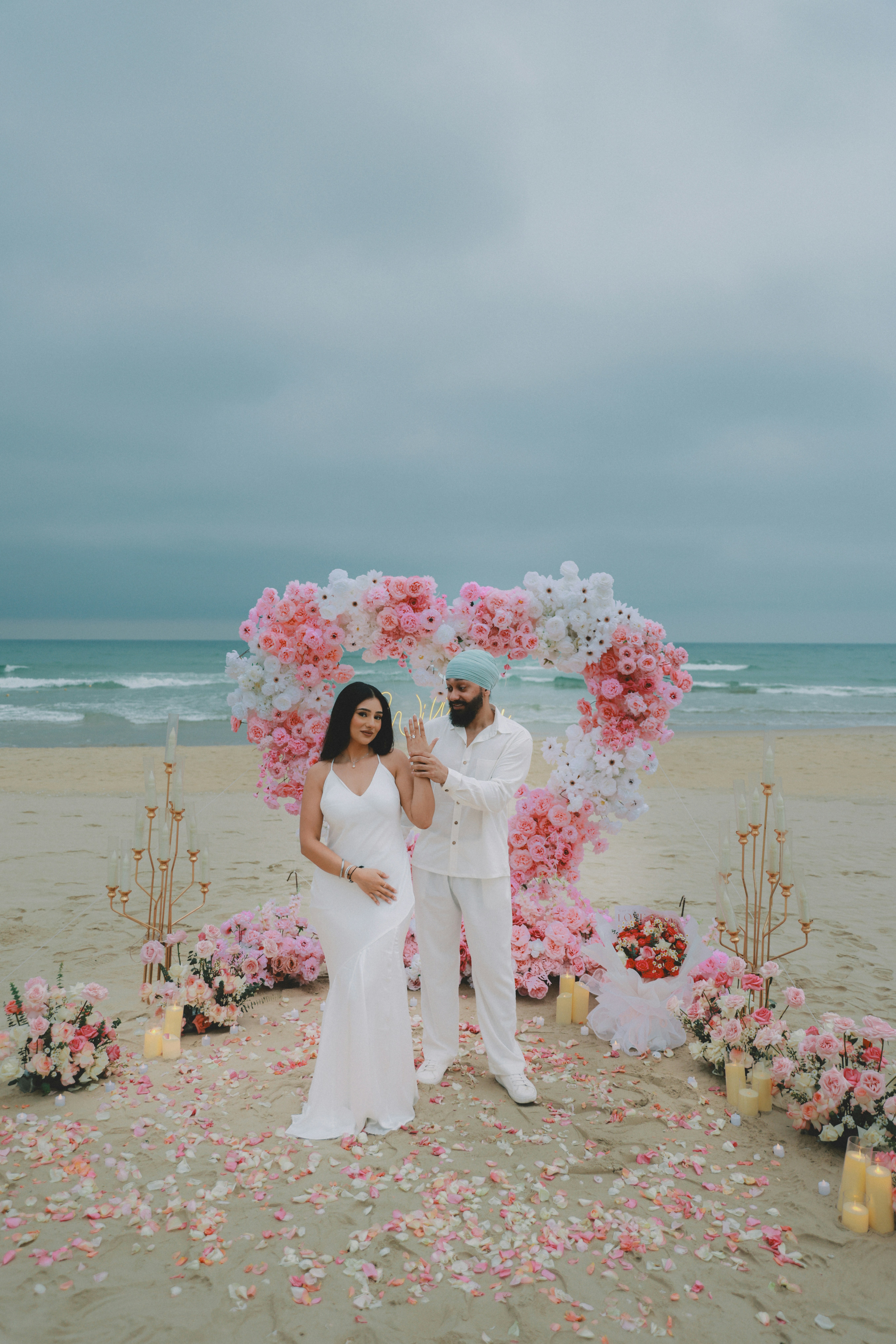 Un couple fêtant sa grossesse sur une plage décorée