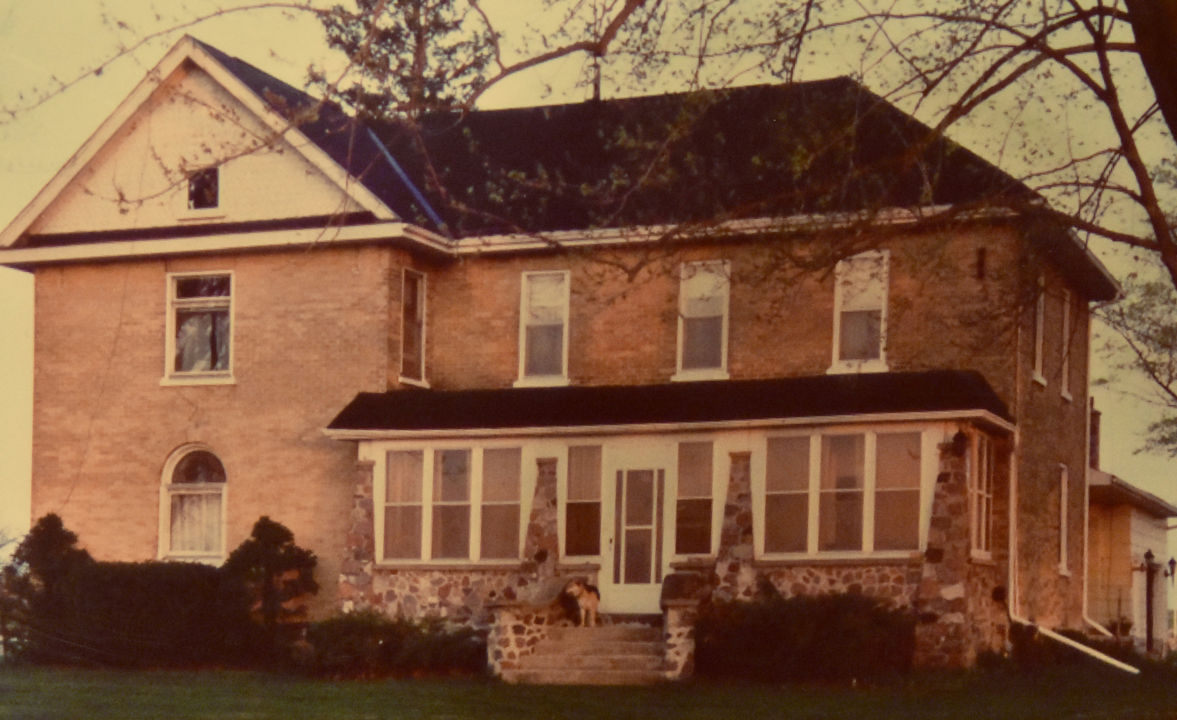 A two-story brick house with a stone foundation.