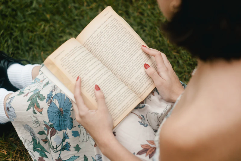 Someone reading an open book on the grass