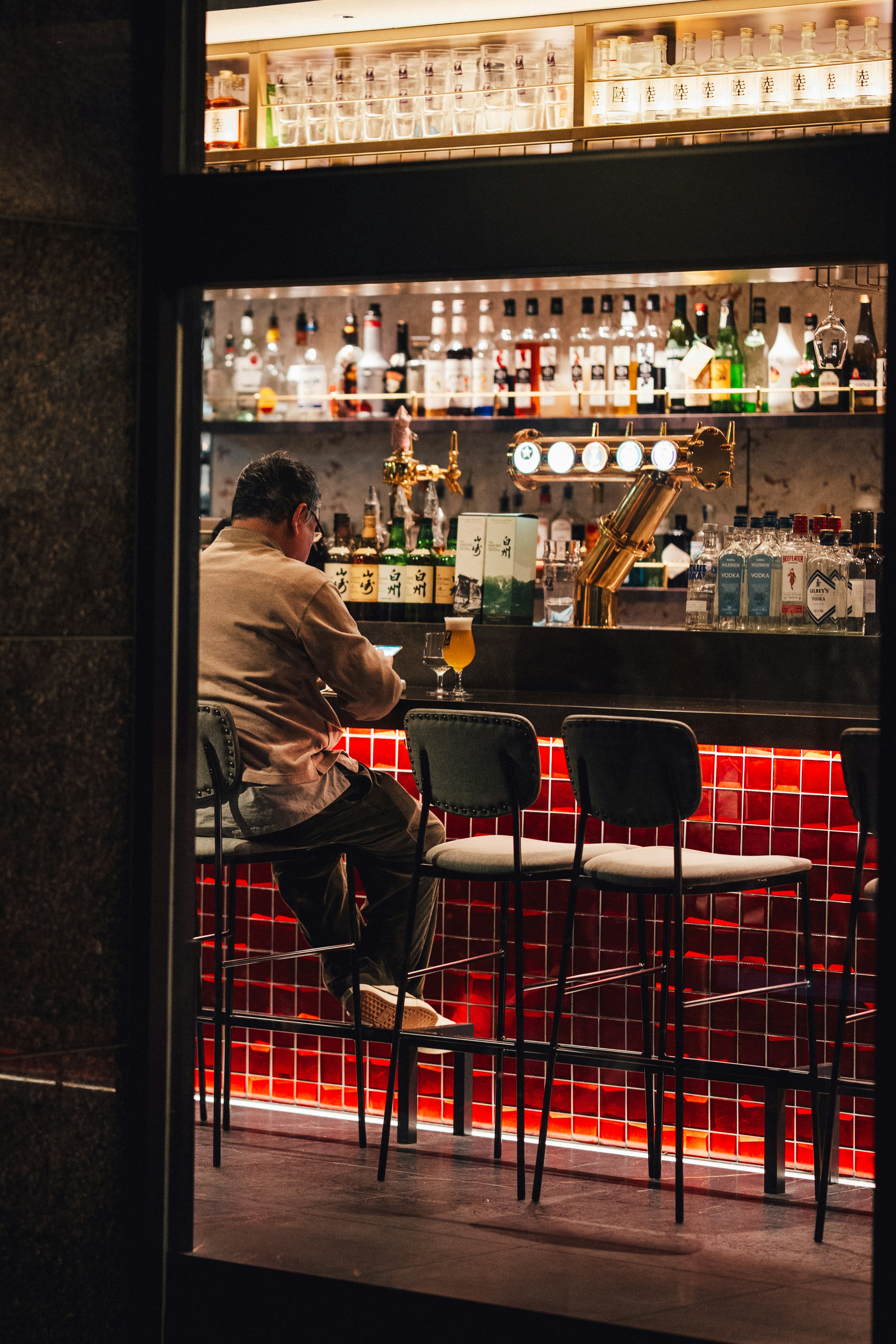 Man sitting alone at a bar with a beer.