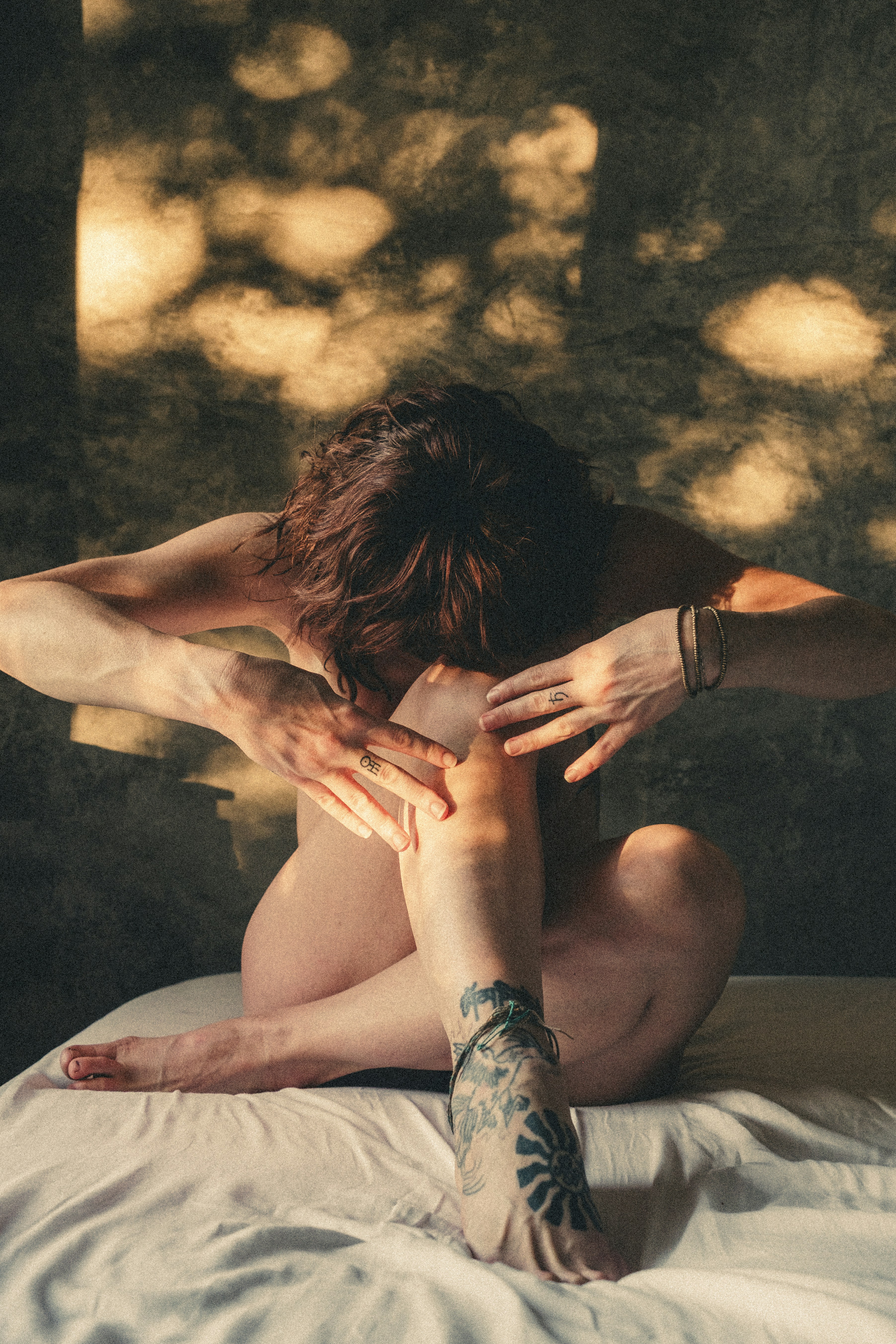 Mujer en postura de yoga sobre una superficie blanca.