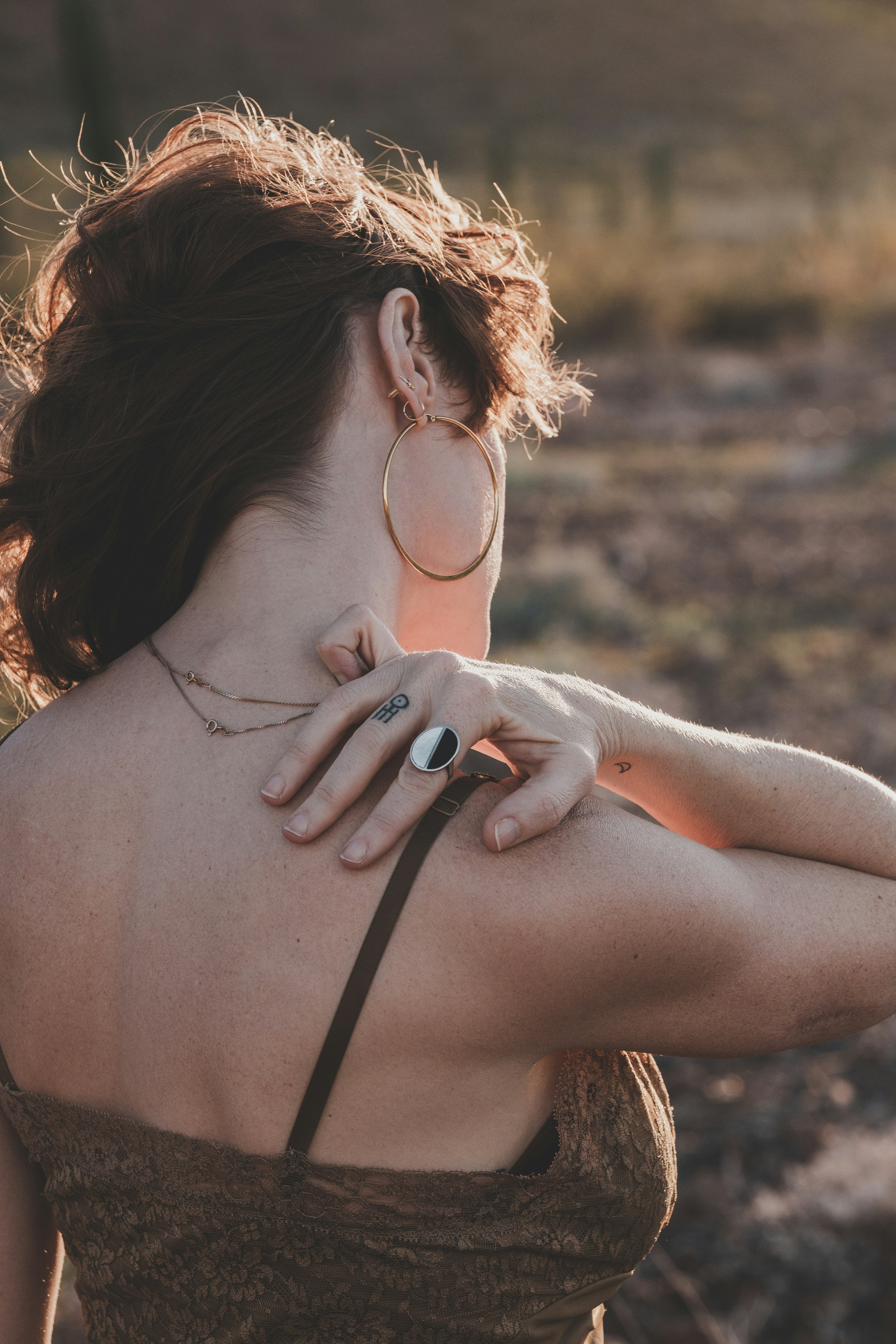 Donna con orecchini a cerchio e un anello all'aperto