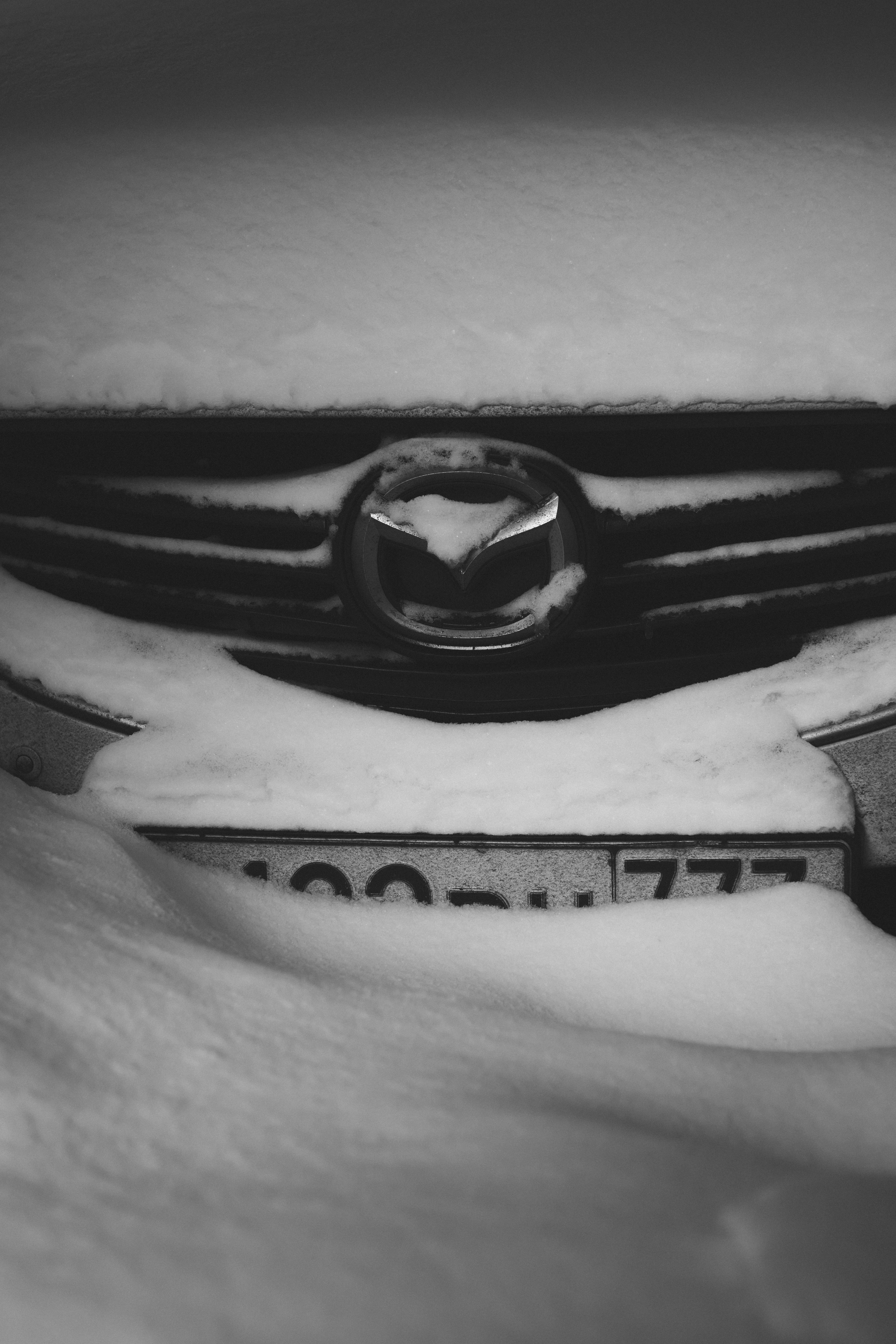 Mazda car grille covered in snow