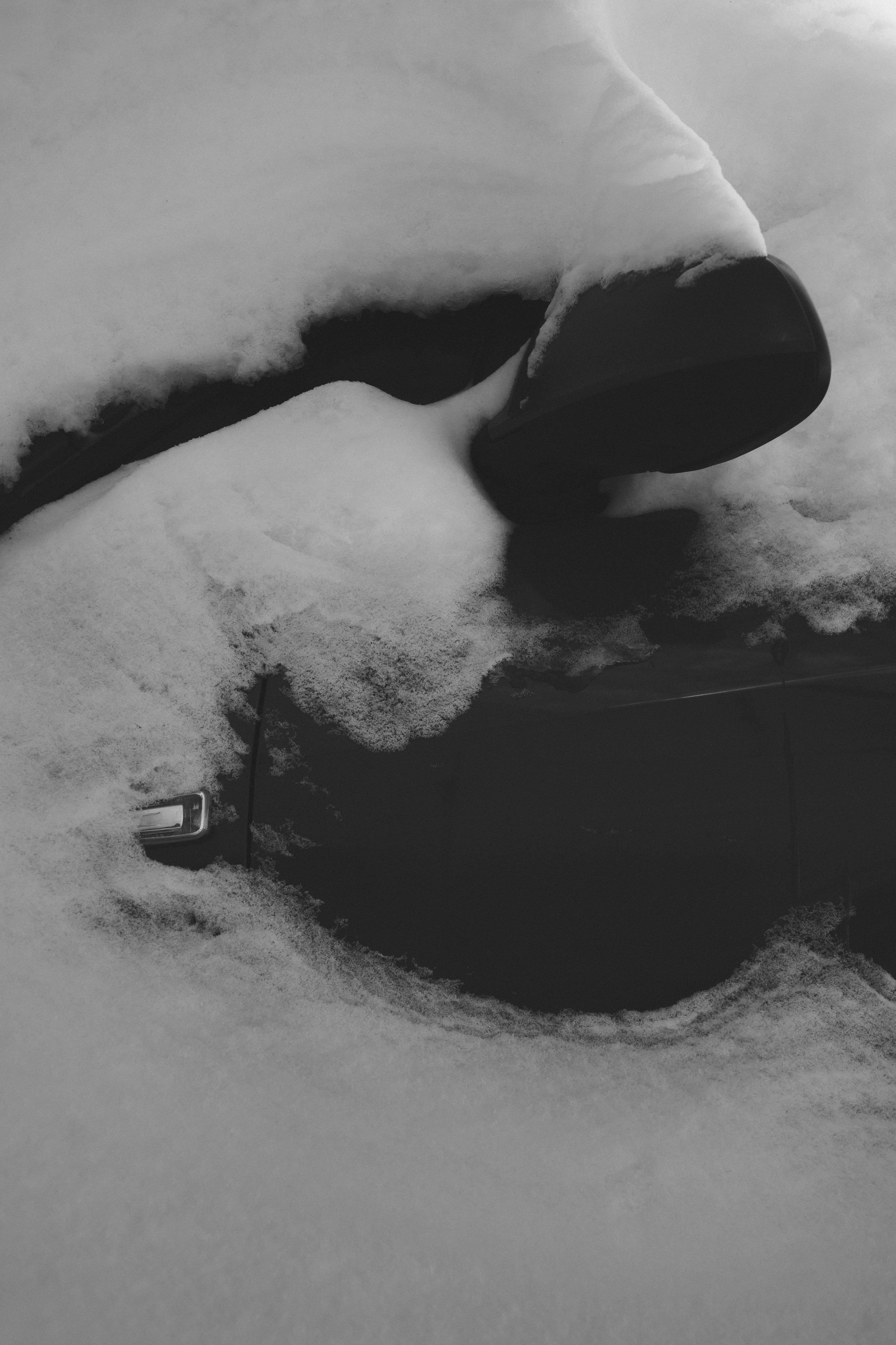 Car door and side mirror covered in snow