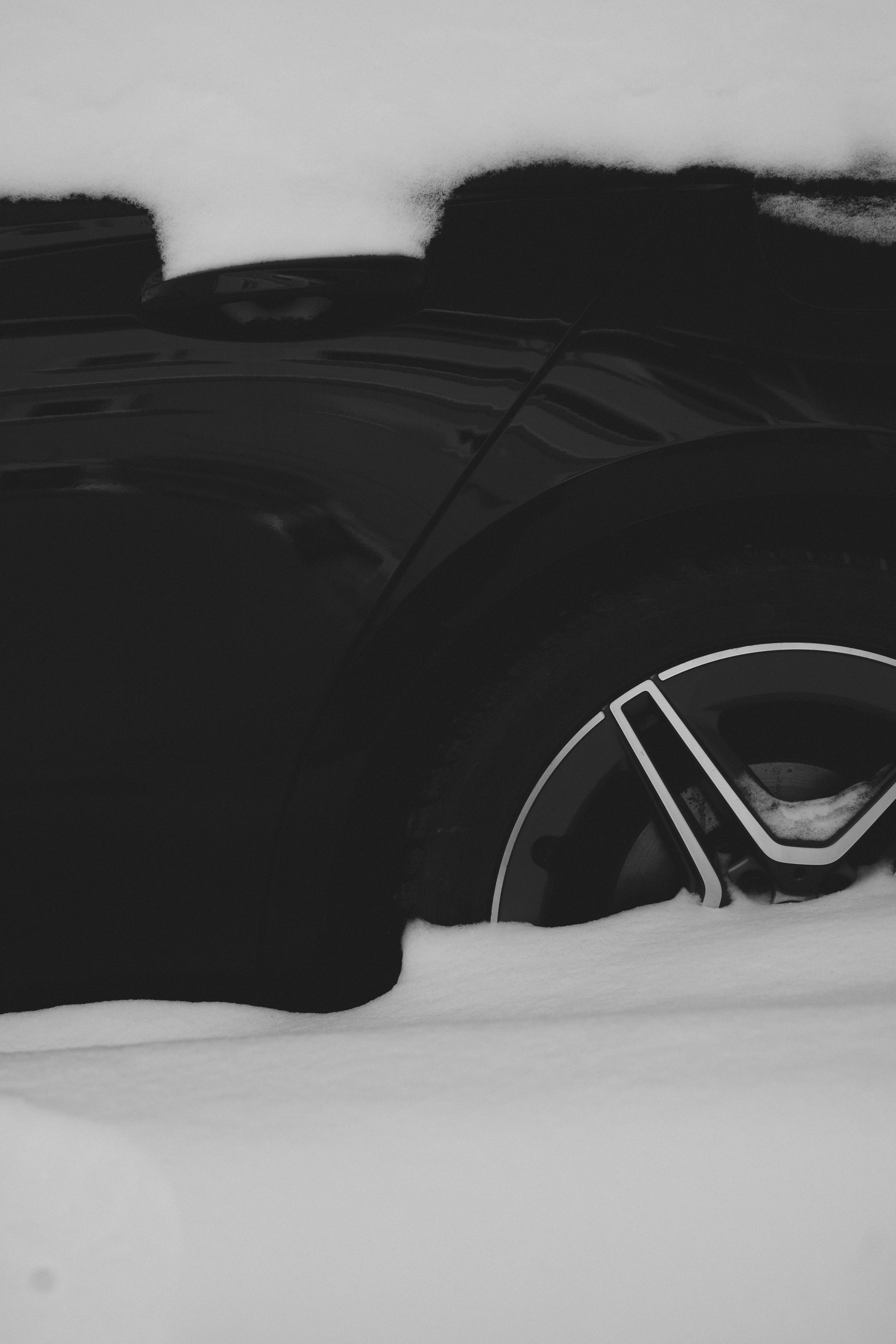 A black car partially buried in snow.