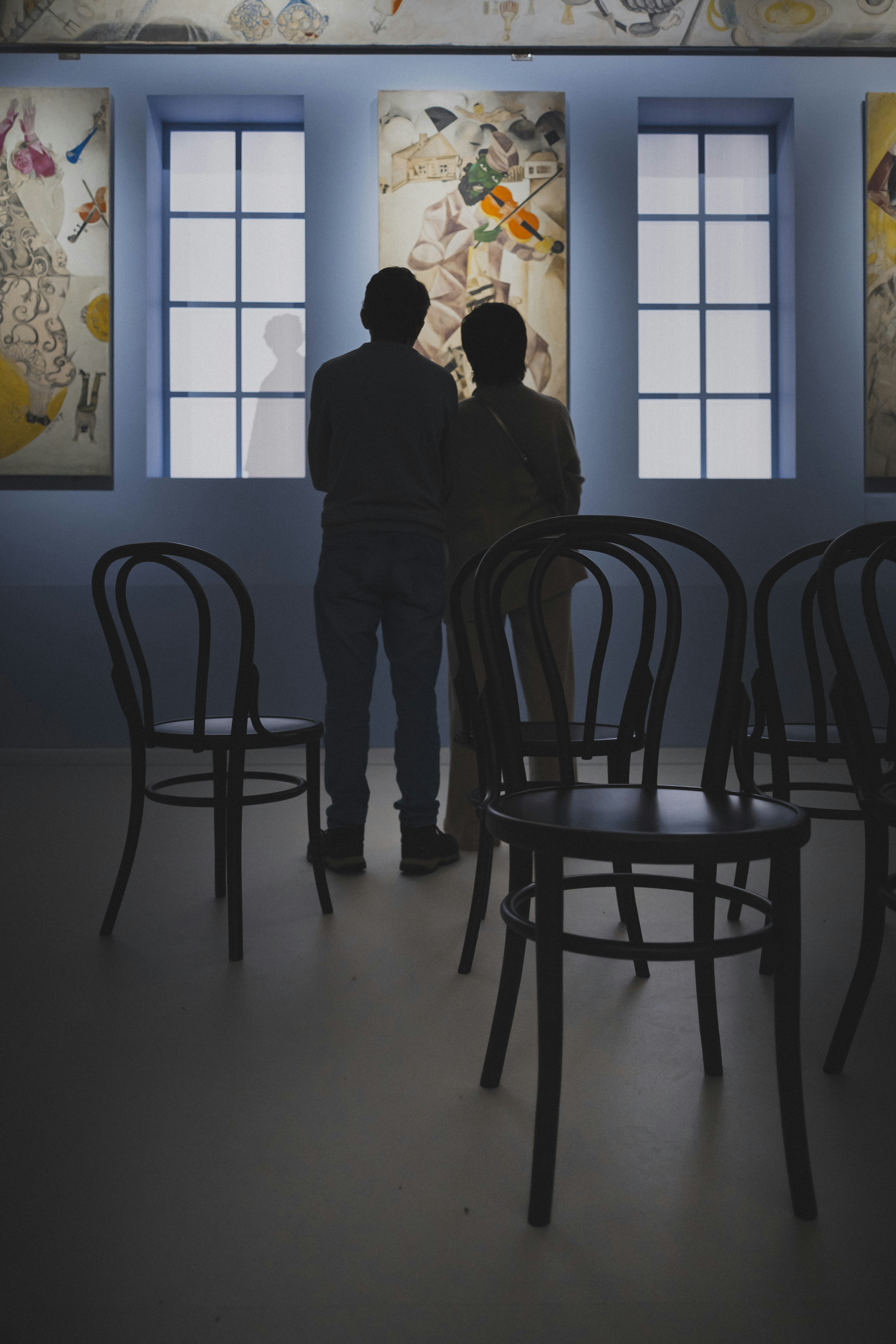 Two people observe art in a gallery.