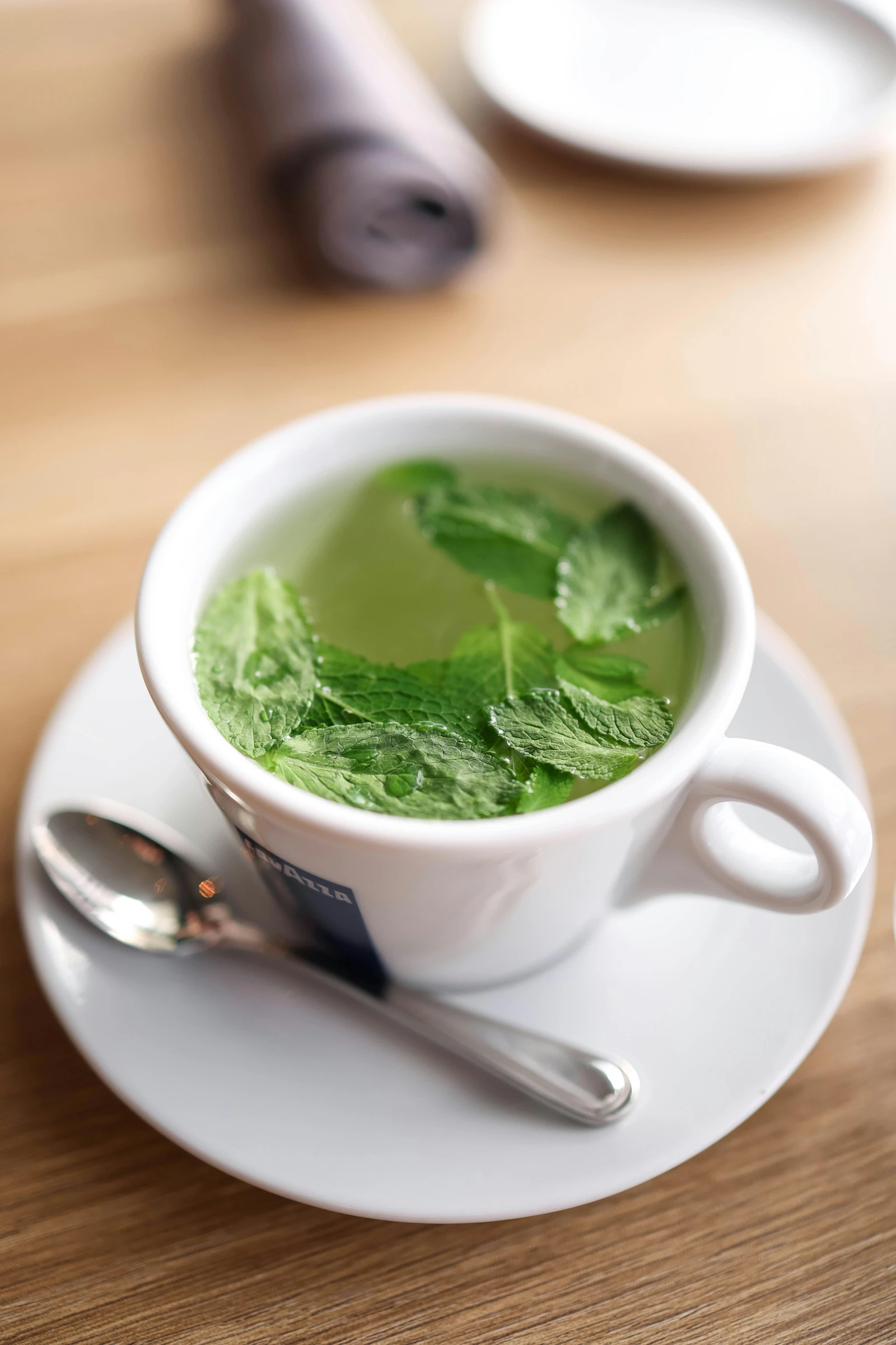 Taza de infusión con hojas de menta fresca alrededor
