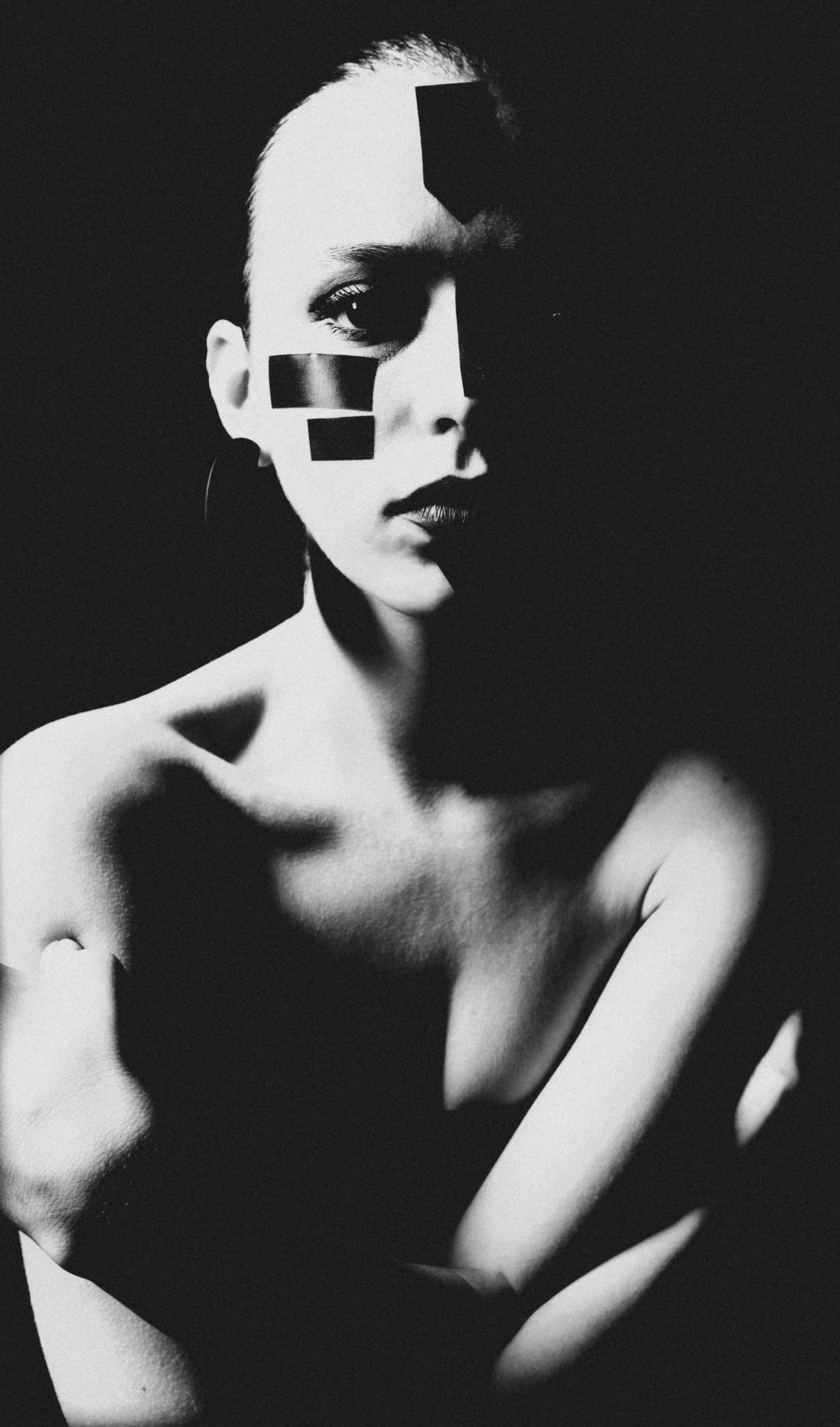 Frau mit Klebeband im Gesicht vor dunklem Hintergrund