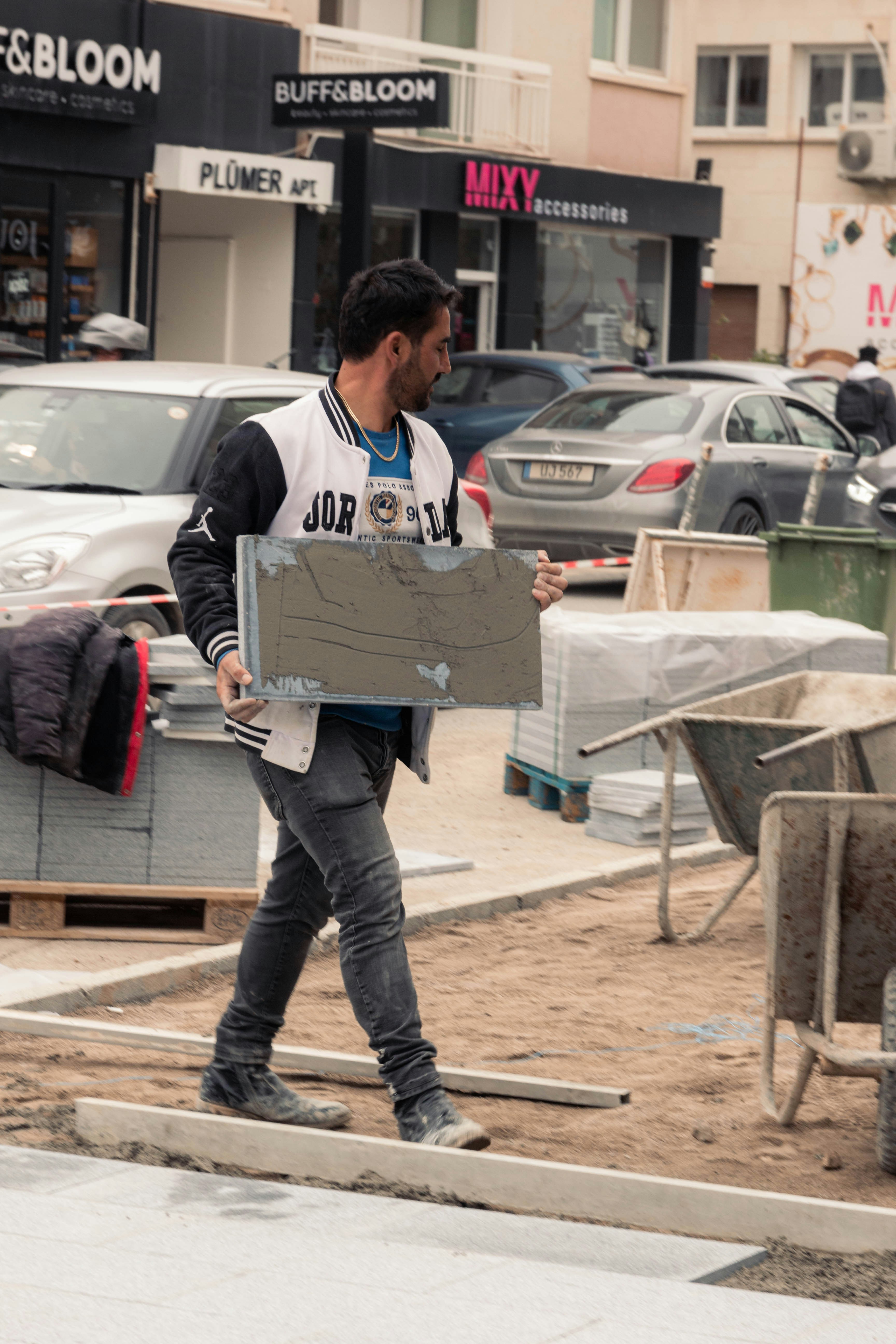 A man carrying tiles on a construction site
