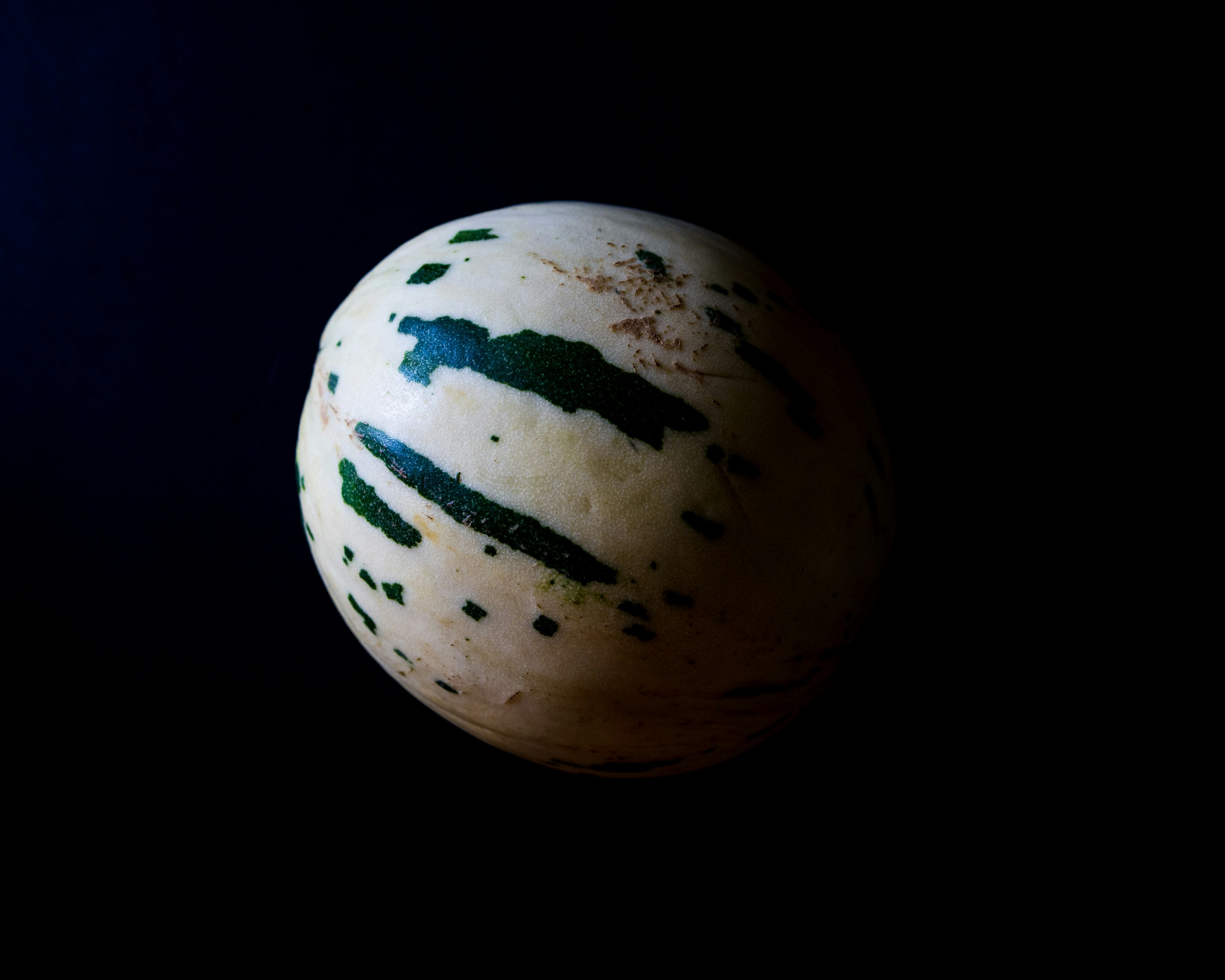 A striped melon on a black background