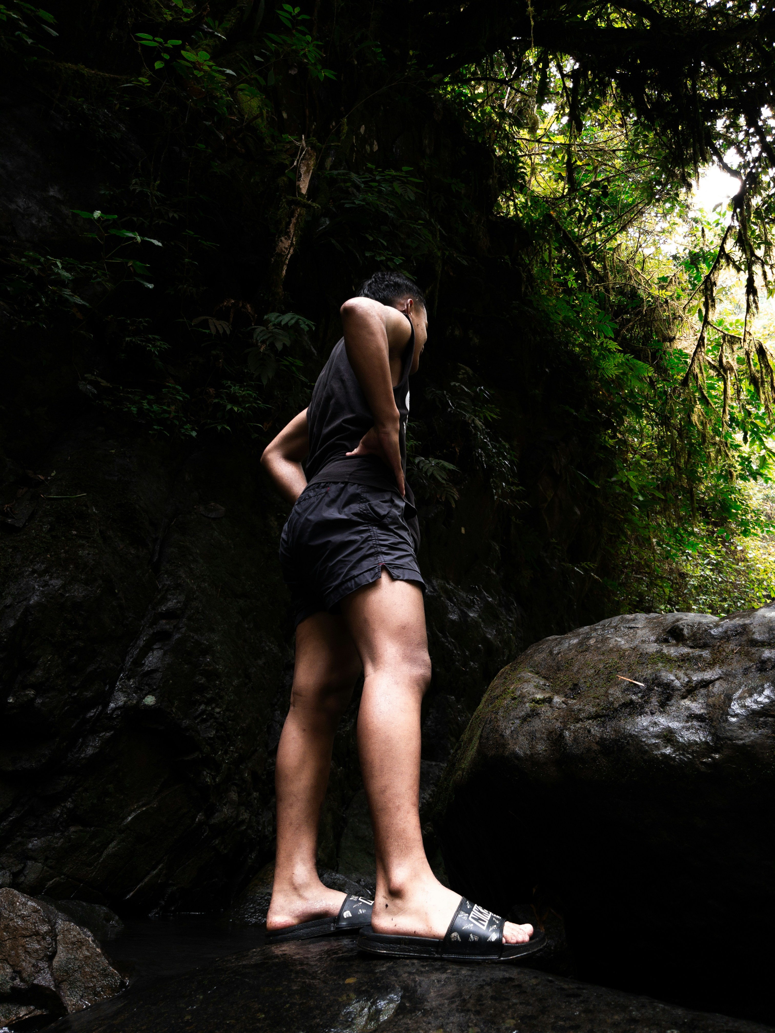 Seseorang berdiri di dekat air terjun berbatu