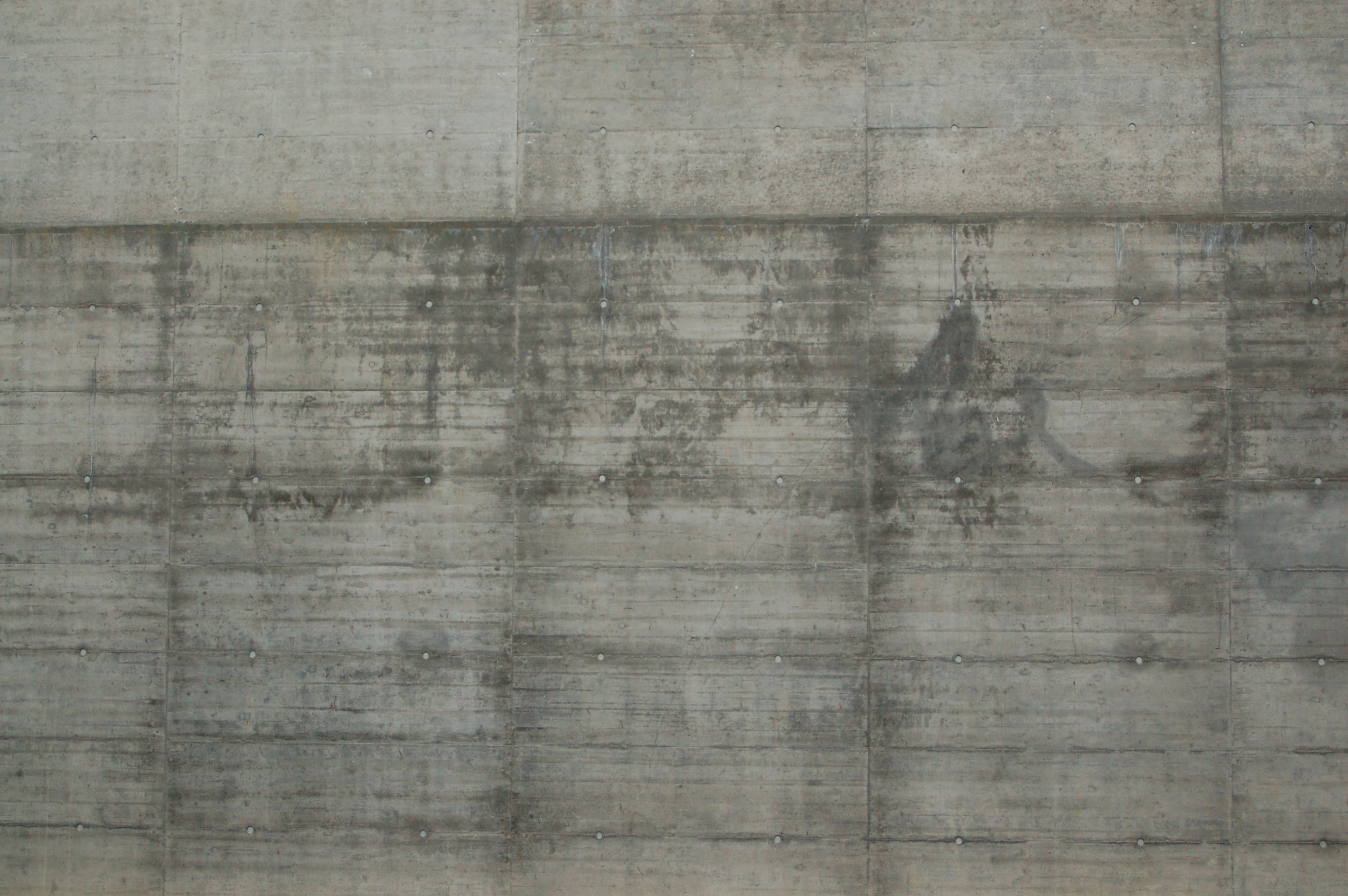 A textured concrete wall with water stains.