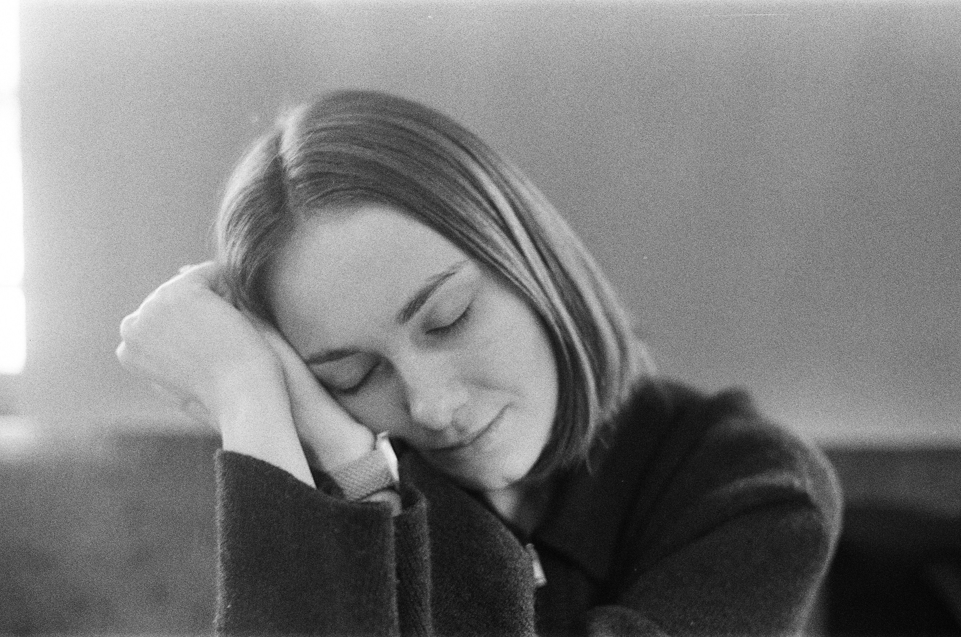 A young woman with eyes closed resting her head