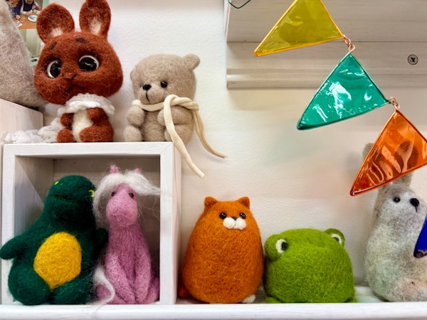 カラフルな旗と並ぶフェルトの動物たち（イメージ）