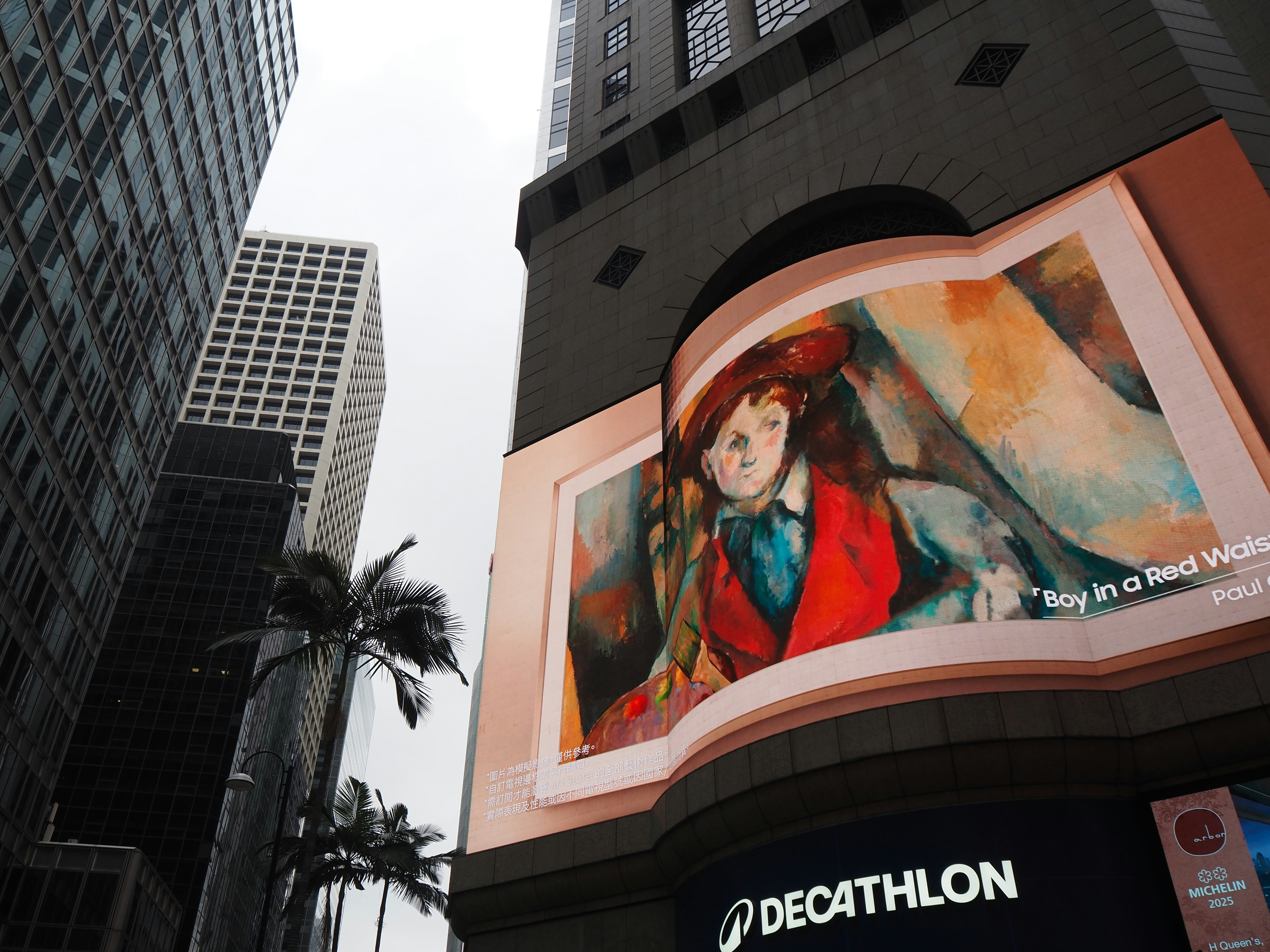 Obras de arte expuestas en la fachada de un edificio con rascacielos.