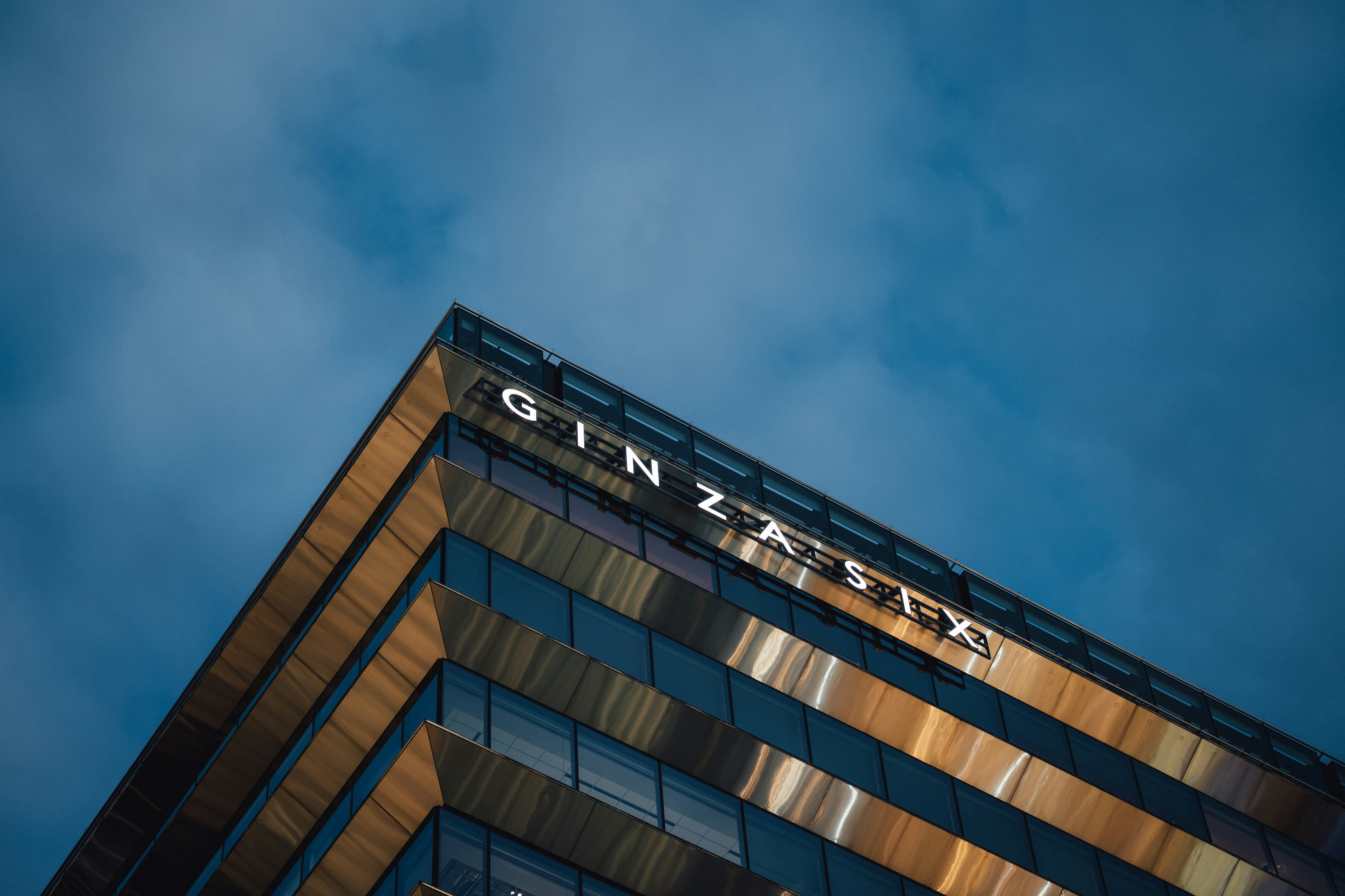 Modern building with "ginzala" sign against blue sky