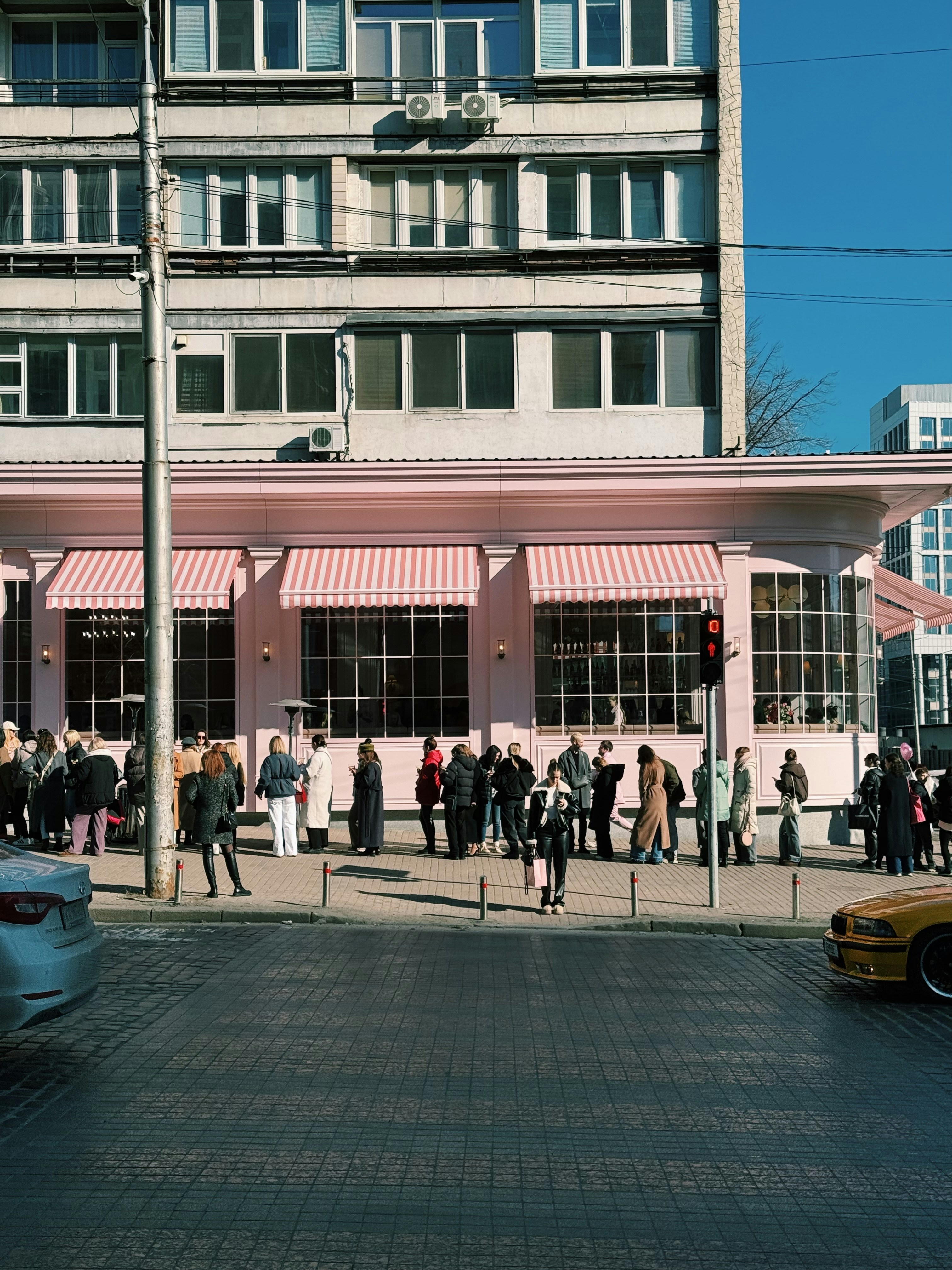 People gathered outside a building in the sun