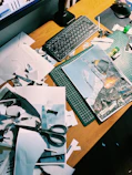 Messy desk with scattered papers, scissors, and a keyboard.