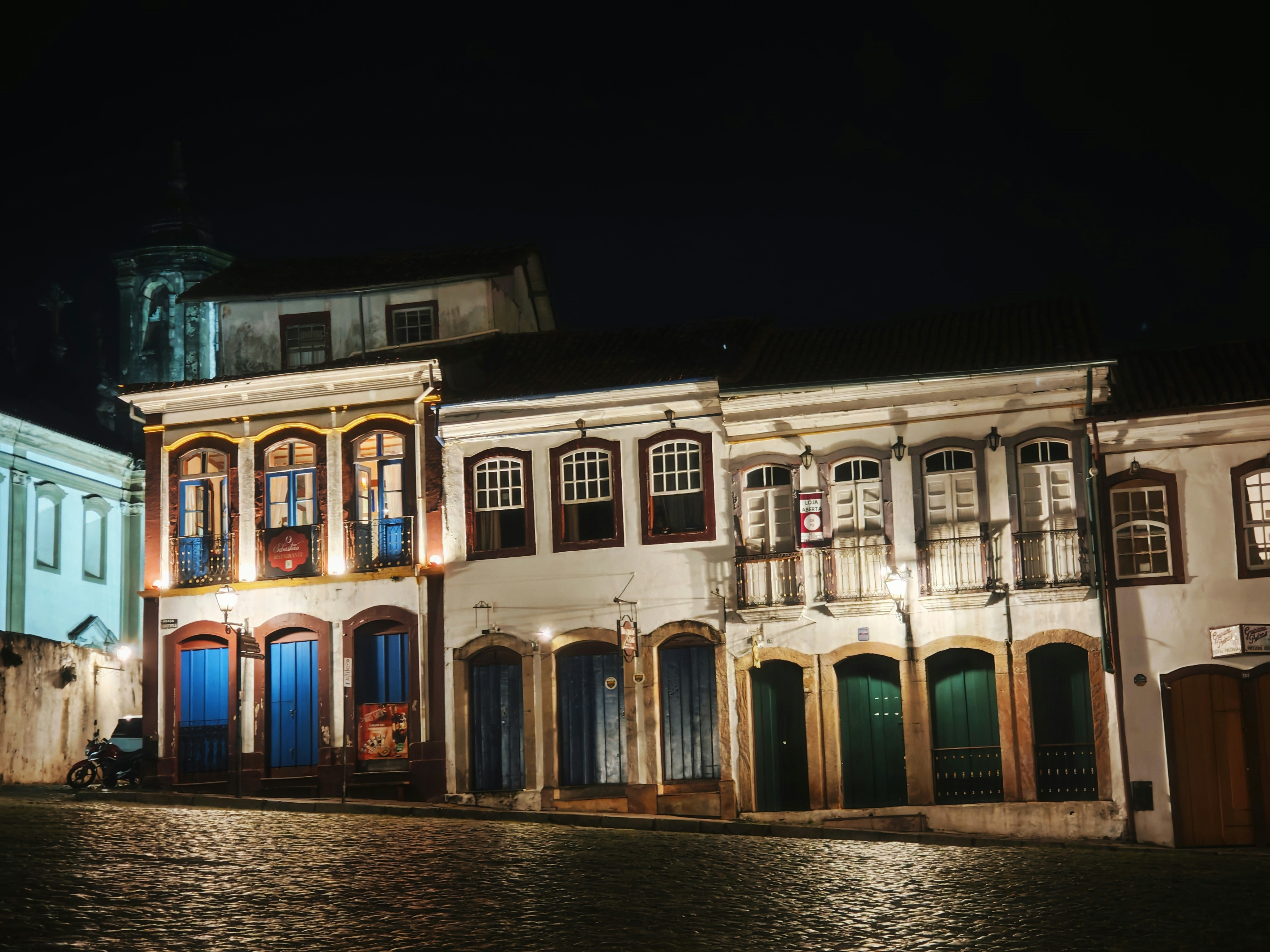 Edificios coloniales históricos iluminados por la noche.