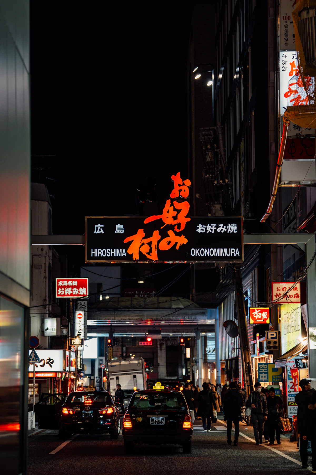 An illuminated Hiroshima food street near Okonomimura at night