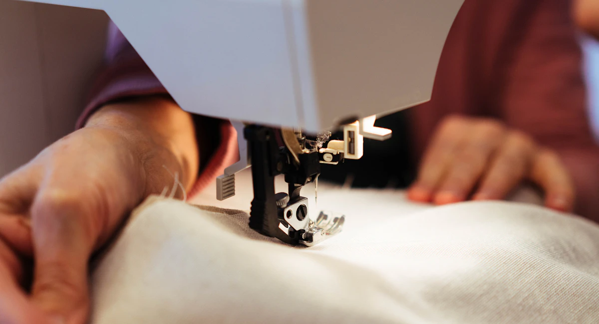 Hands guiding fabric through a sewing machine